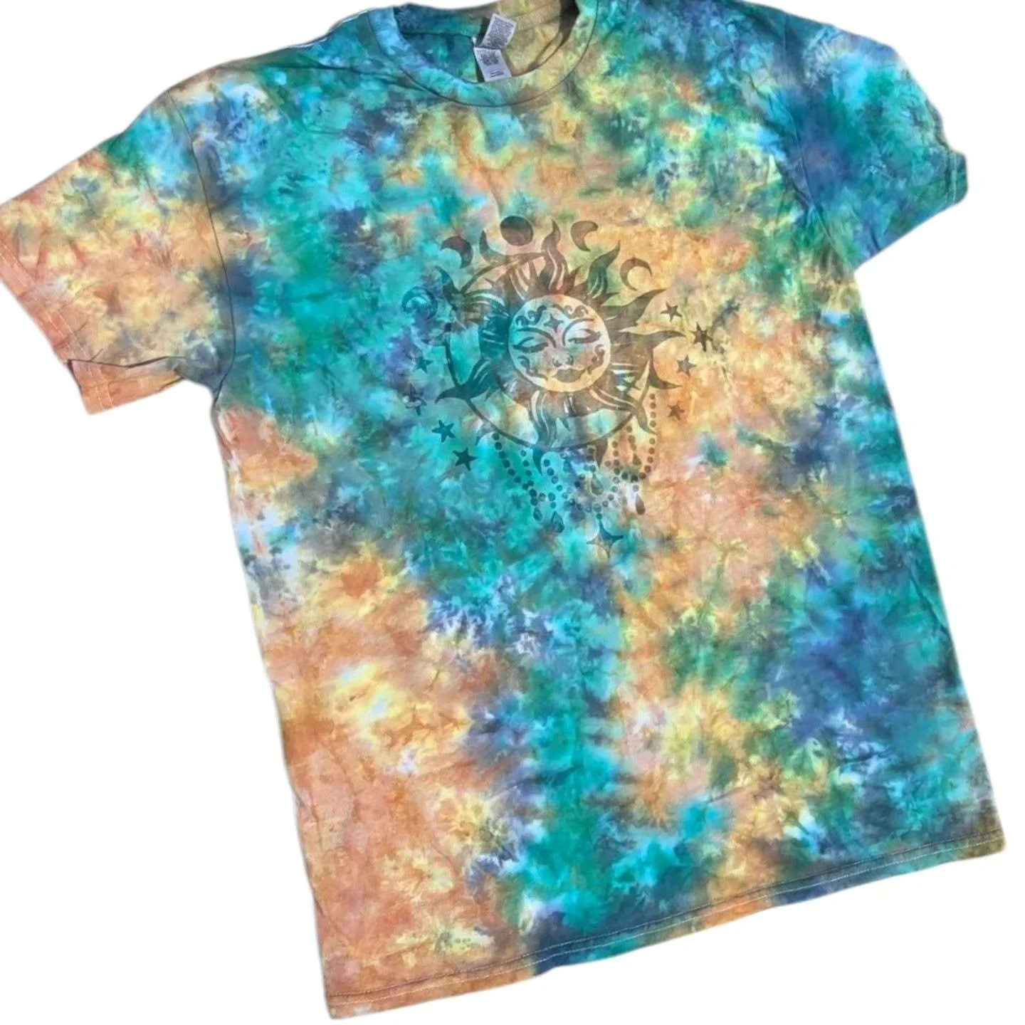 Colorful tie-dye T-shirt with a black sun and moon face design in the center, surrounded by stars.