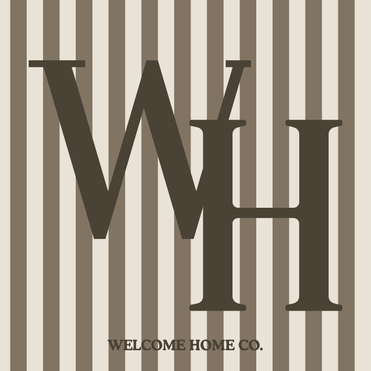 Decorative sign with large brown letters 'W' and 'H' over a beige and brown striped background, and the text 'Welcome Home Co.' at the bottom.