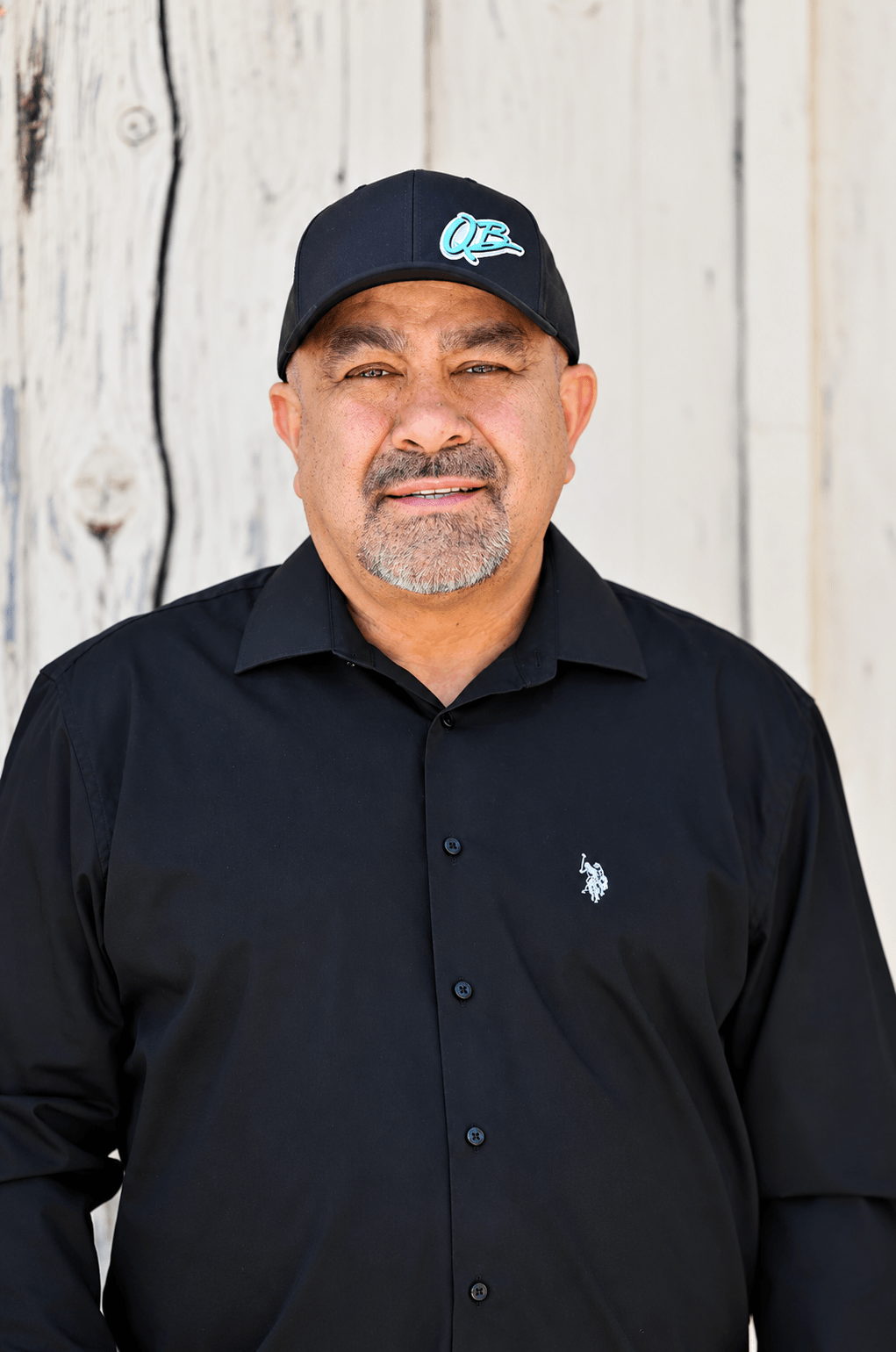 Rudy Leyba, Project Manager at Quality Builders, dressed in all black.