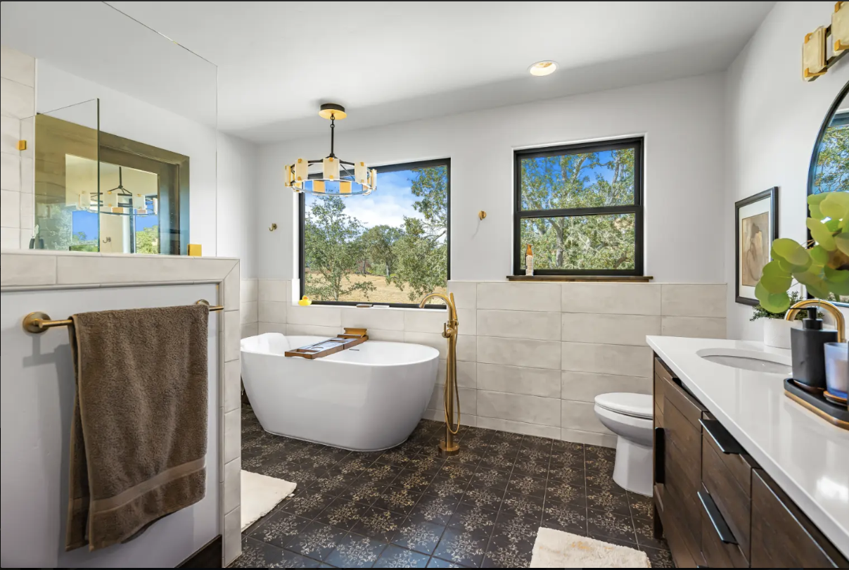 Photo of a standalone tub in a primary bathroom