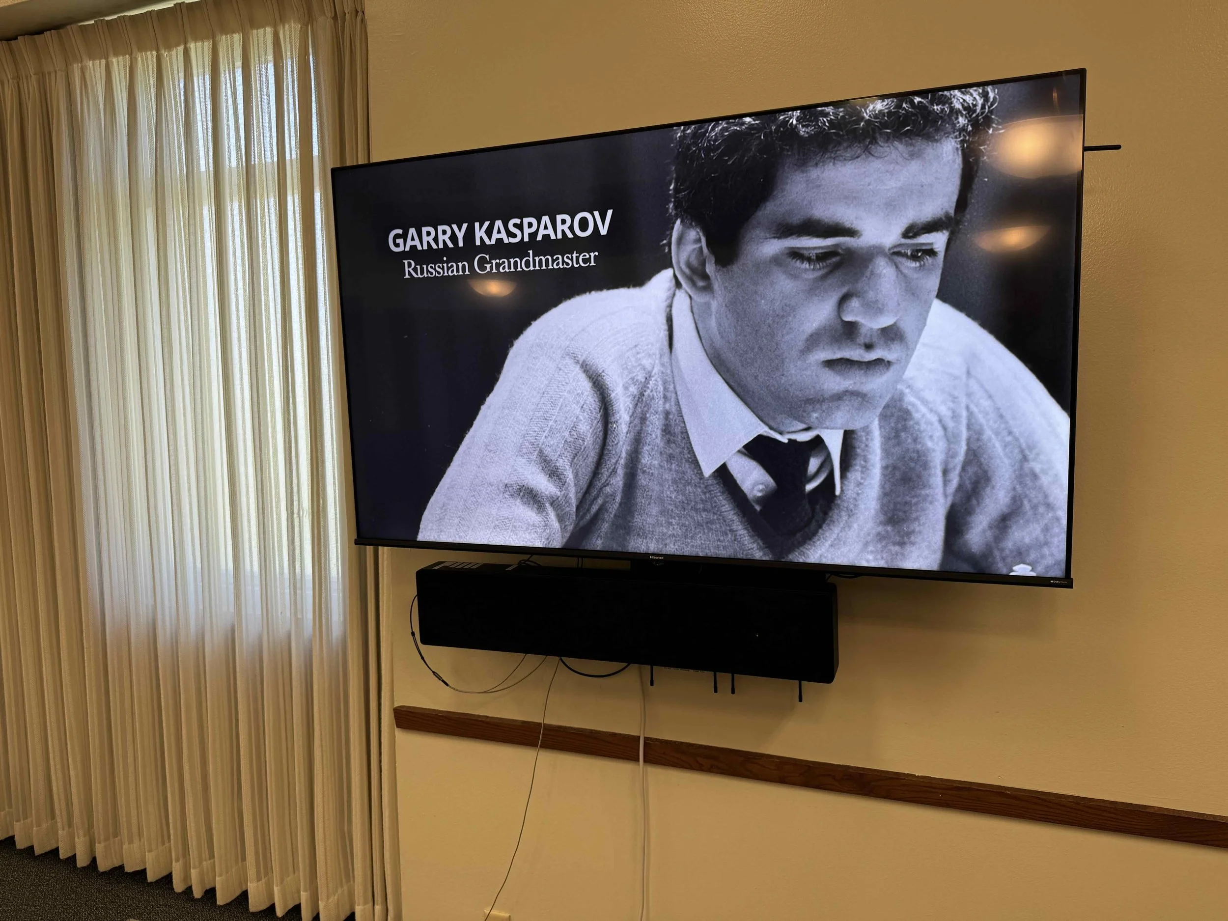 Black and white photo of Garry Kasparov with text overlay saying 'Garry Kasparov, Russian Grandmaster'.