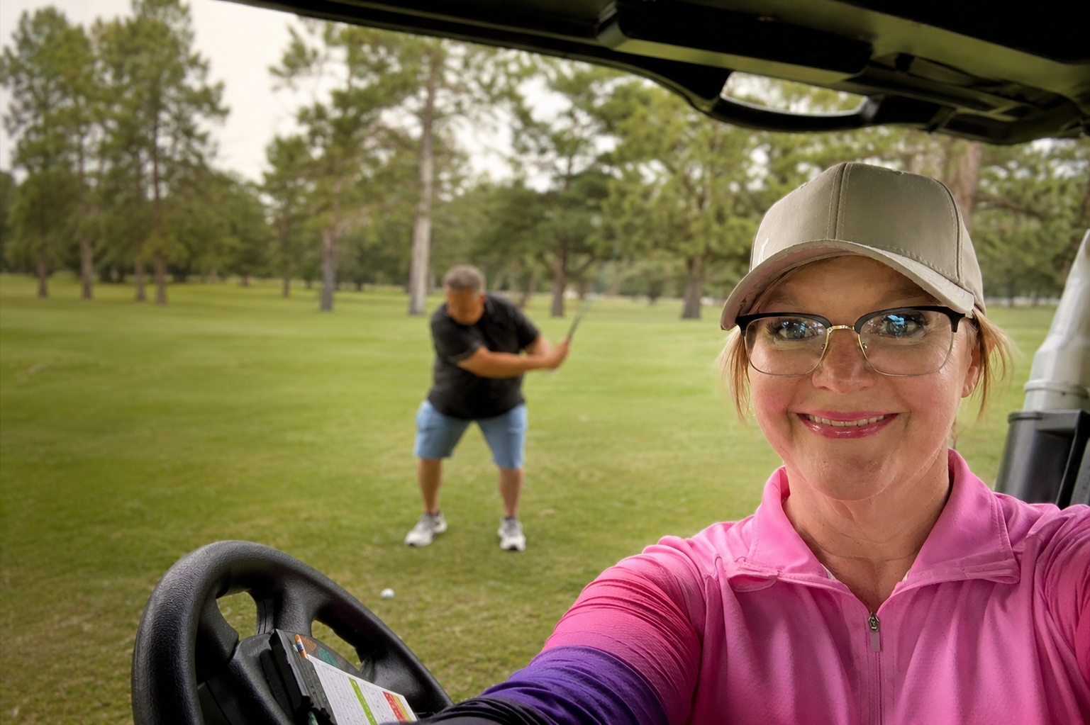 Shannon in a golf cart while Jason prepares to hit a shot on a Minnesota golf course.