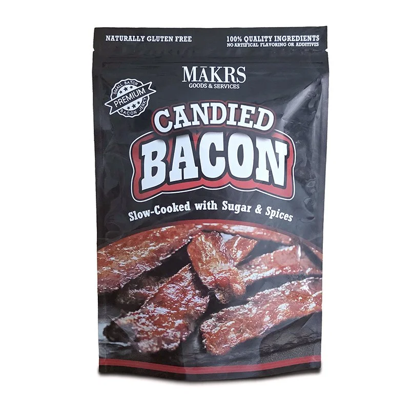 Package of Candied Bacon, slow-cooked with sugar and spices, from MAKRS Goods & Services. The package is black with white and red text, and shows an image of glazed bacon strips.