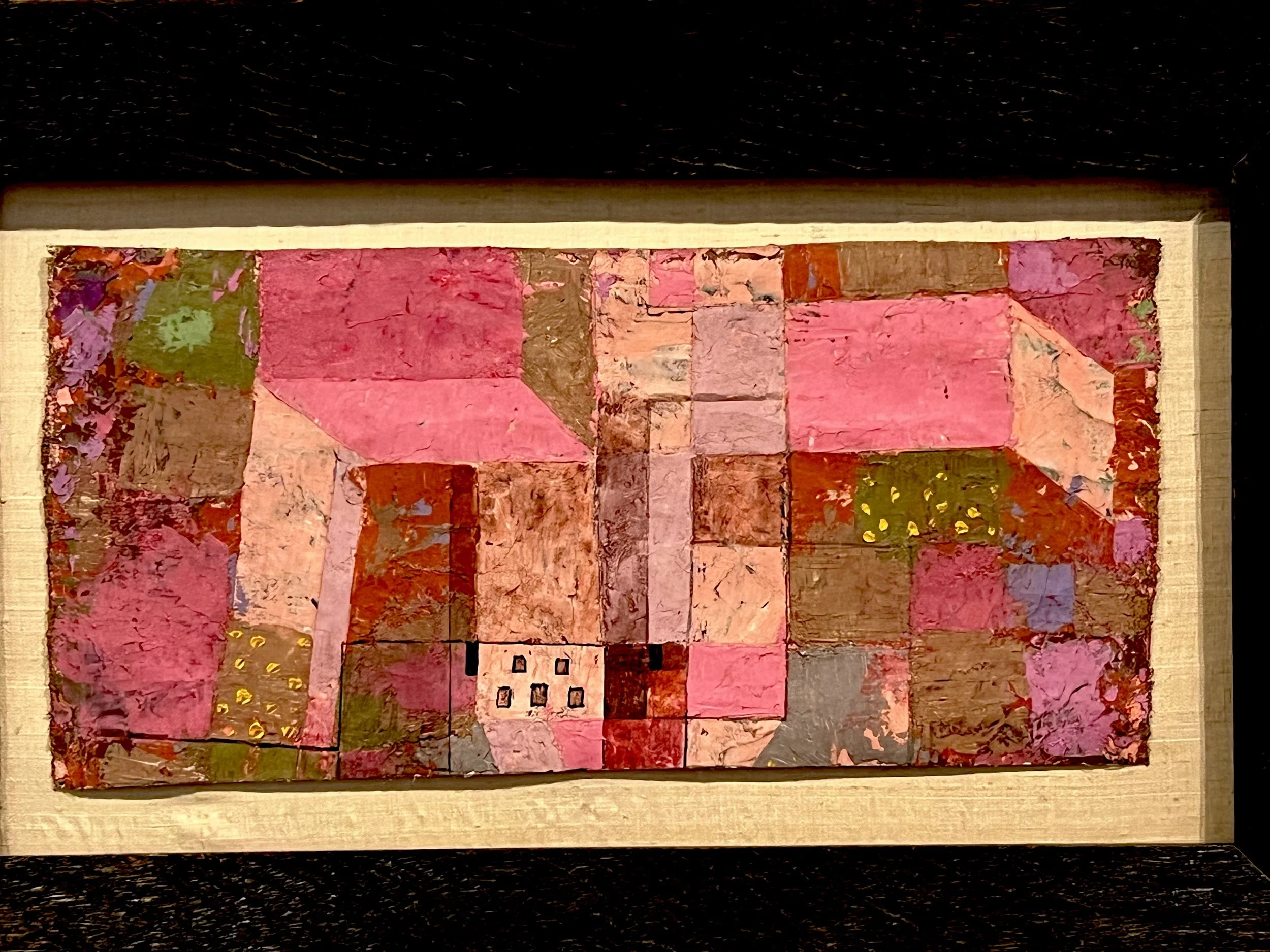 Framed Paul Klee painting of a small town in patchwork blocks of pink, red, rust and green