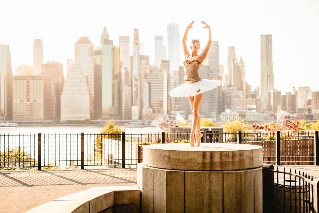Tori Hey performs a classical ballet position in front of the NYC skyline.