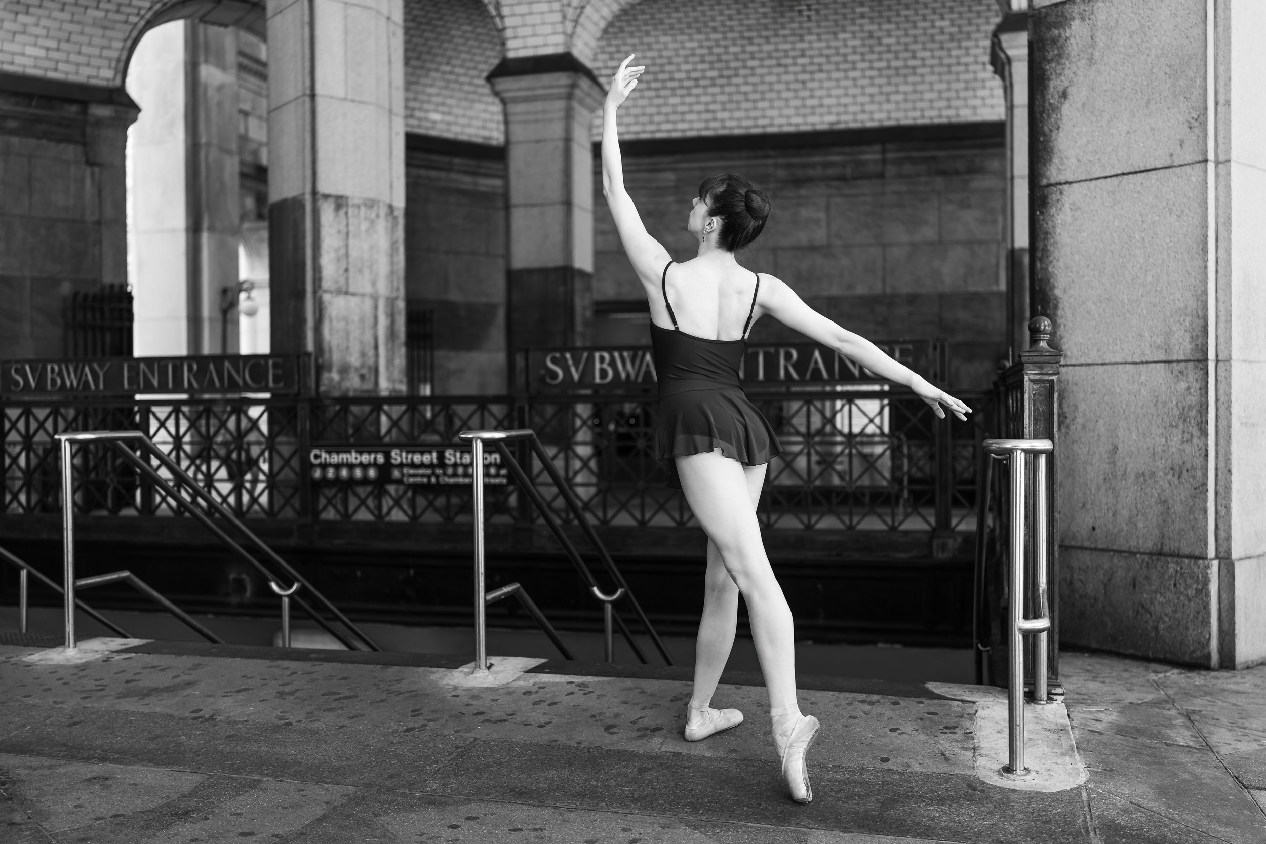 Tori Hey appears in a black-and-white photo performing a ballet pose in an NYC subway station.