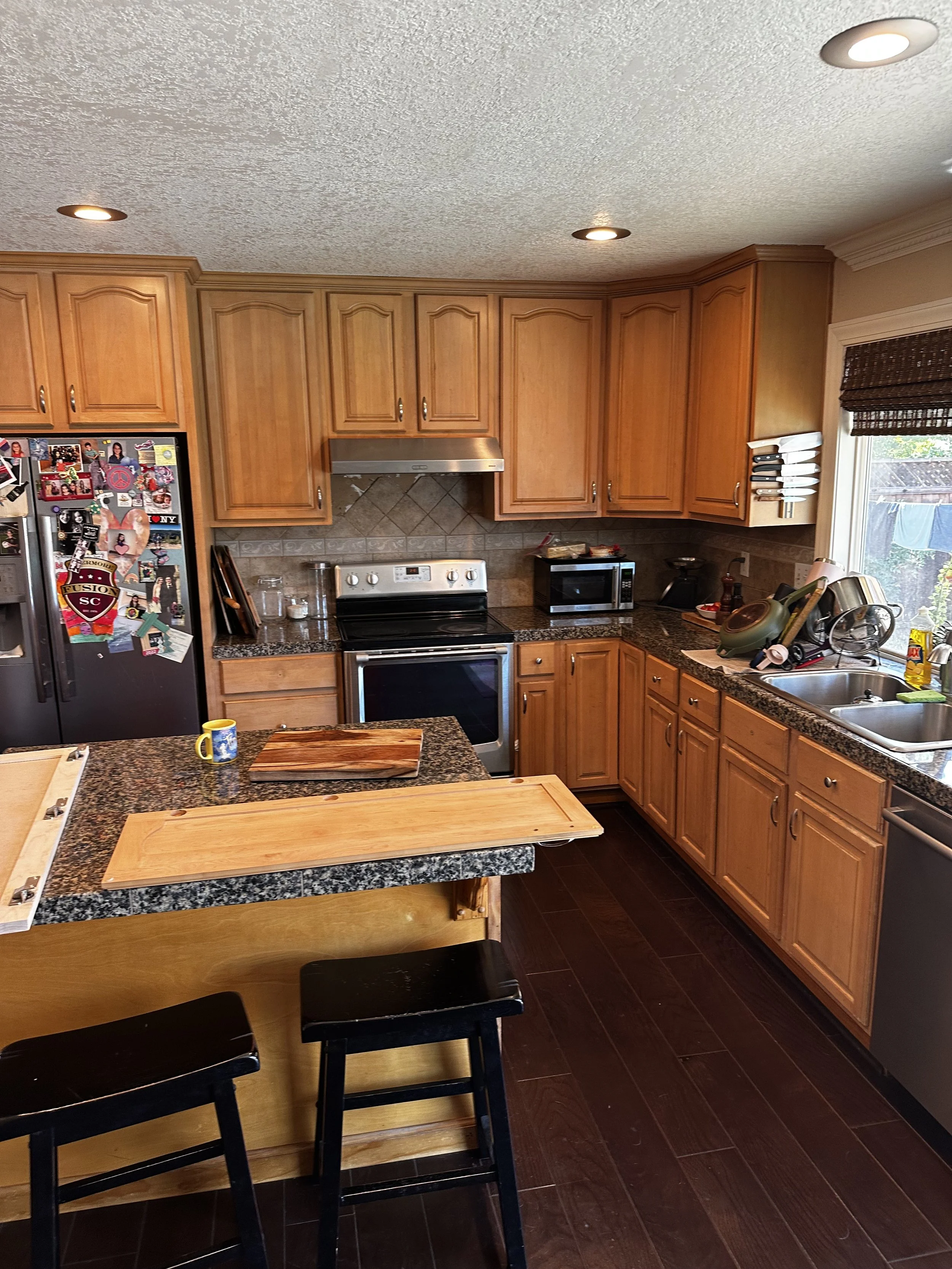 Outdated cabinetry and worn granite countertops.