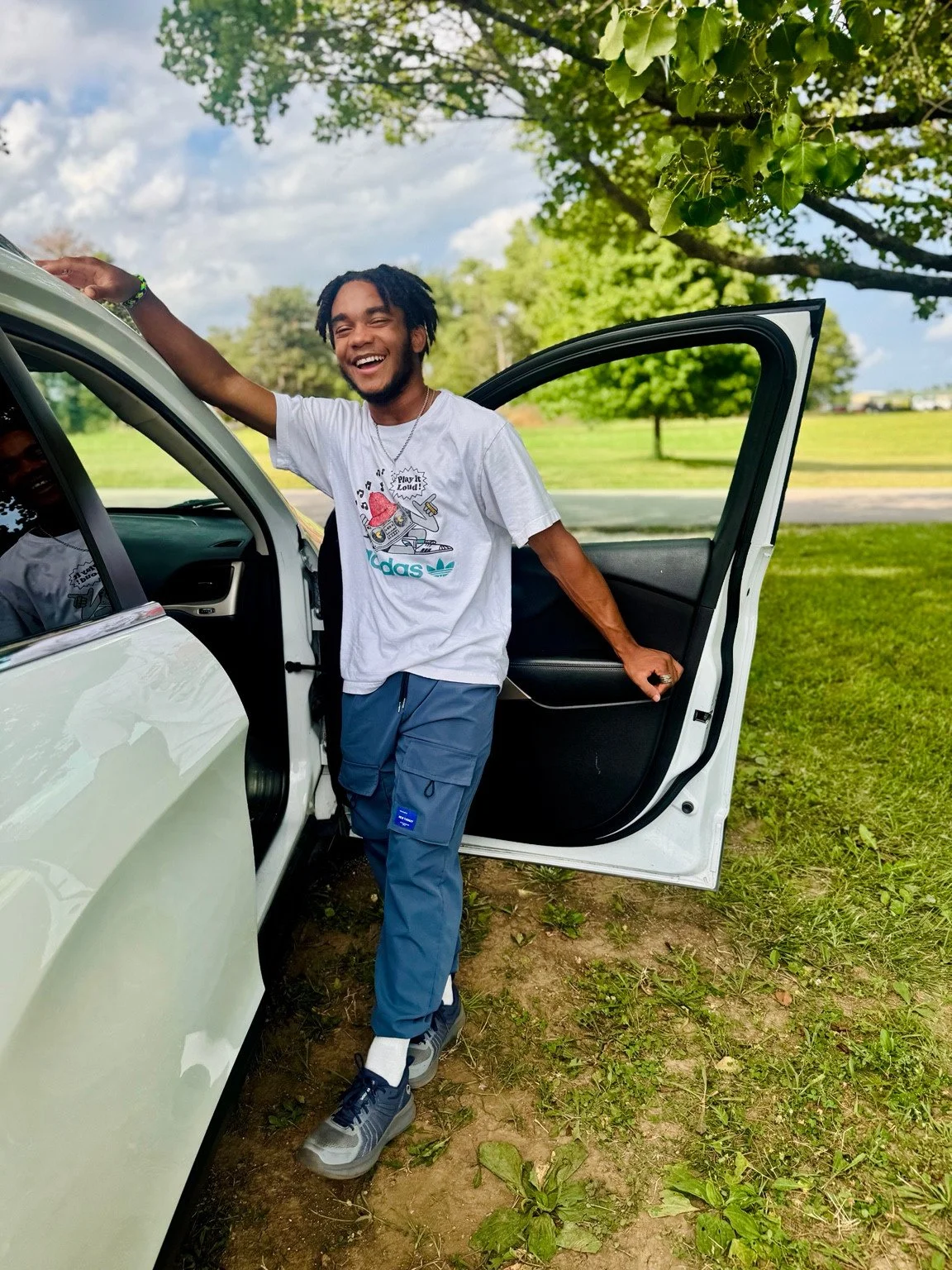 Full length portrait beside an open white car door.