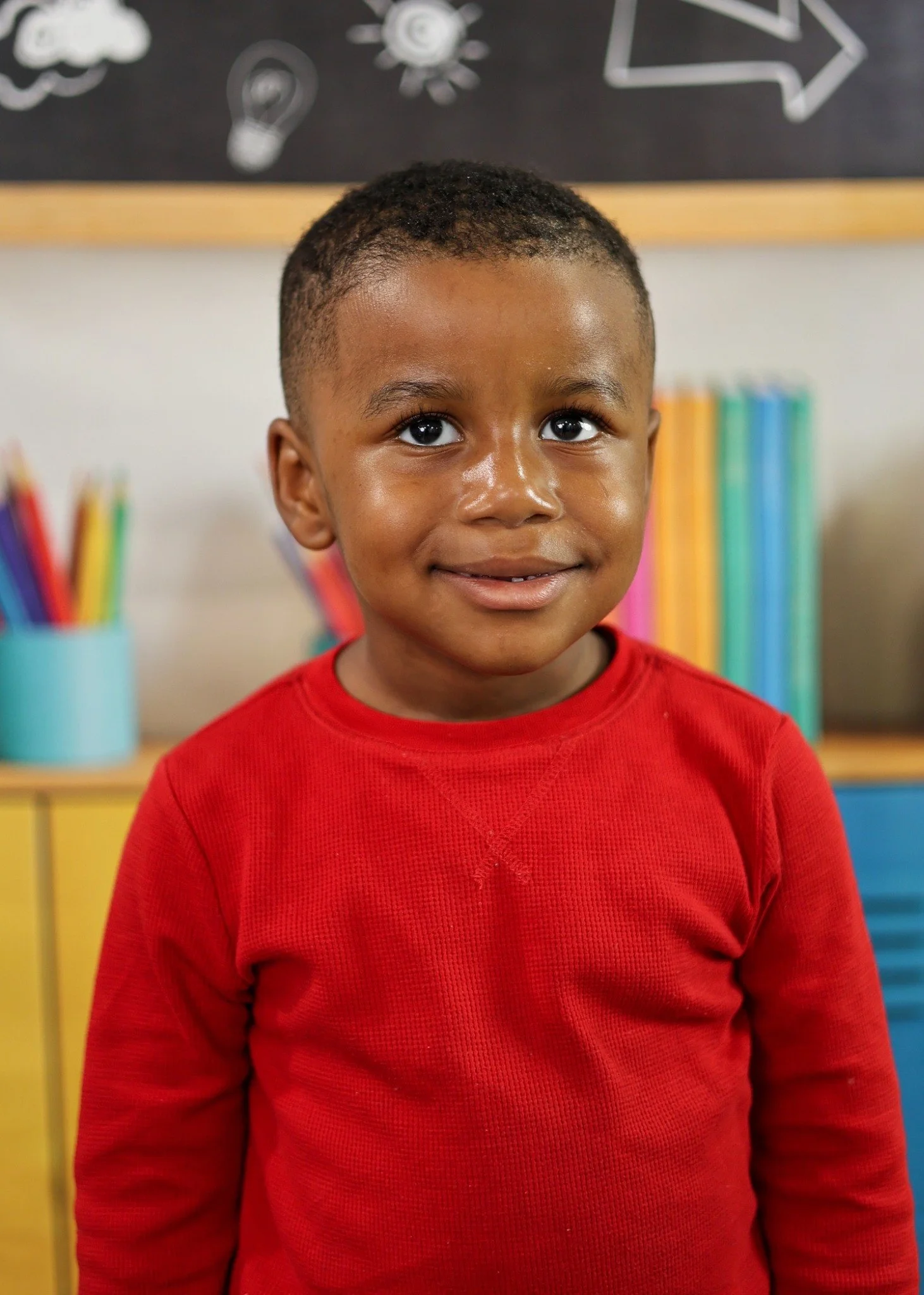 School portrait with a colorful classroom backdrop.