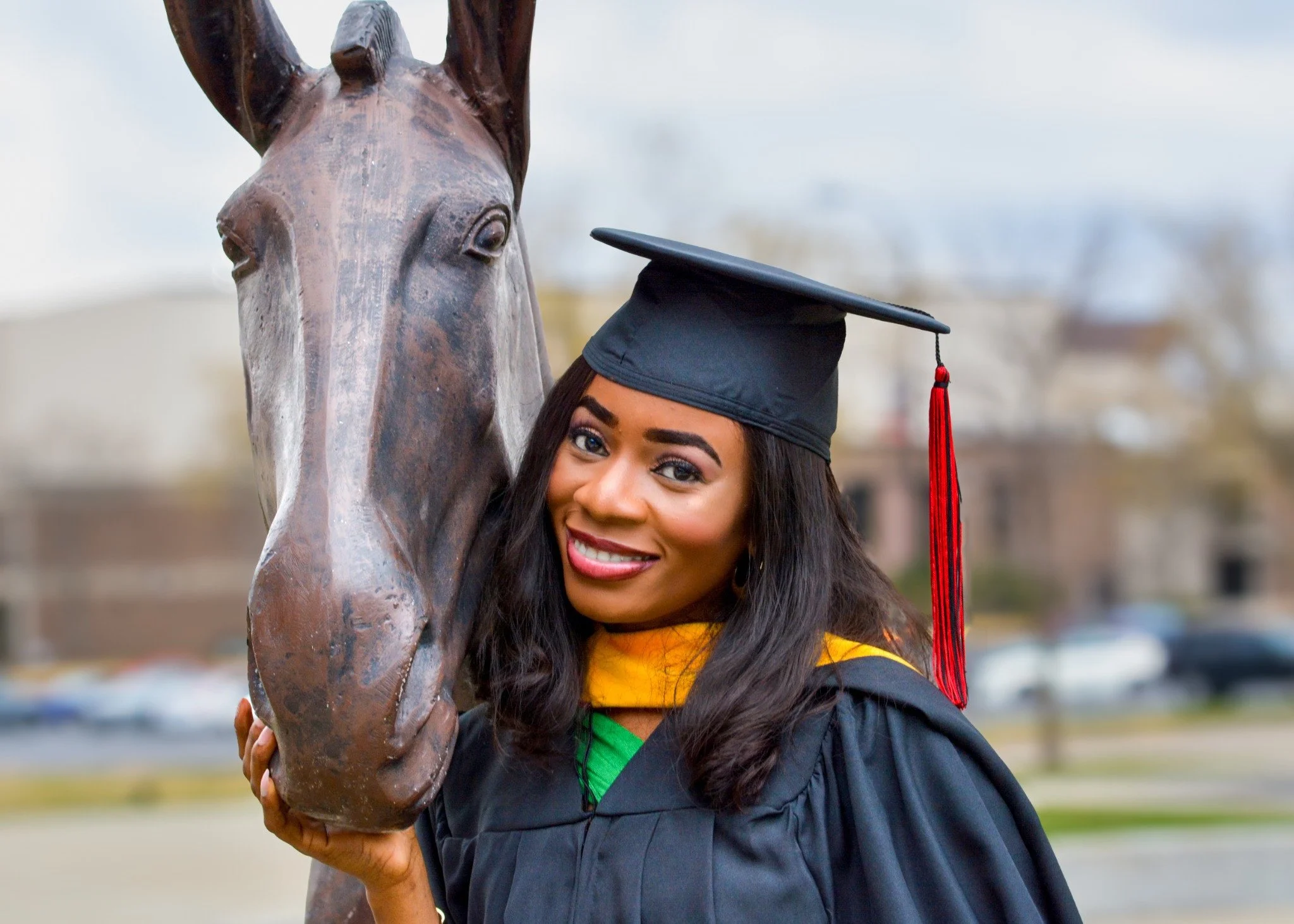 Graduate smiling during an outdoor portrait session.