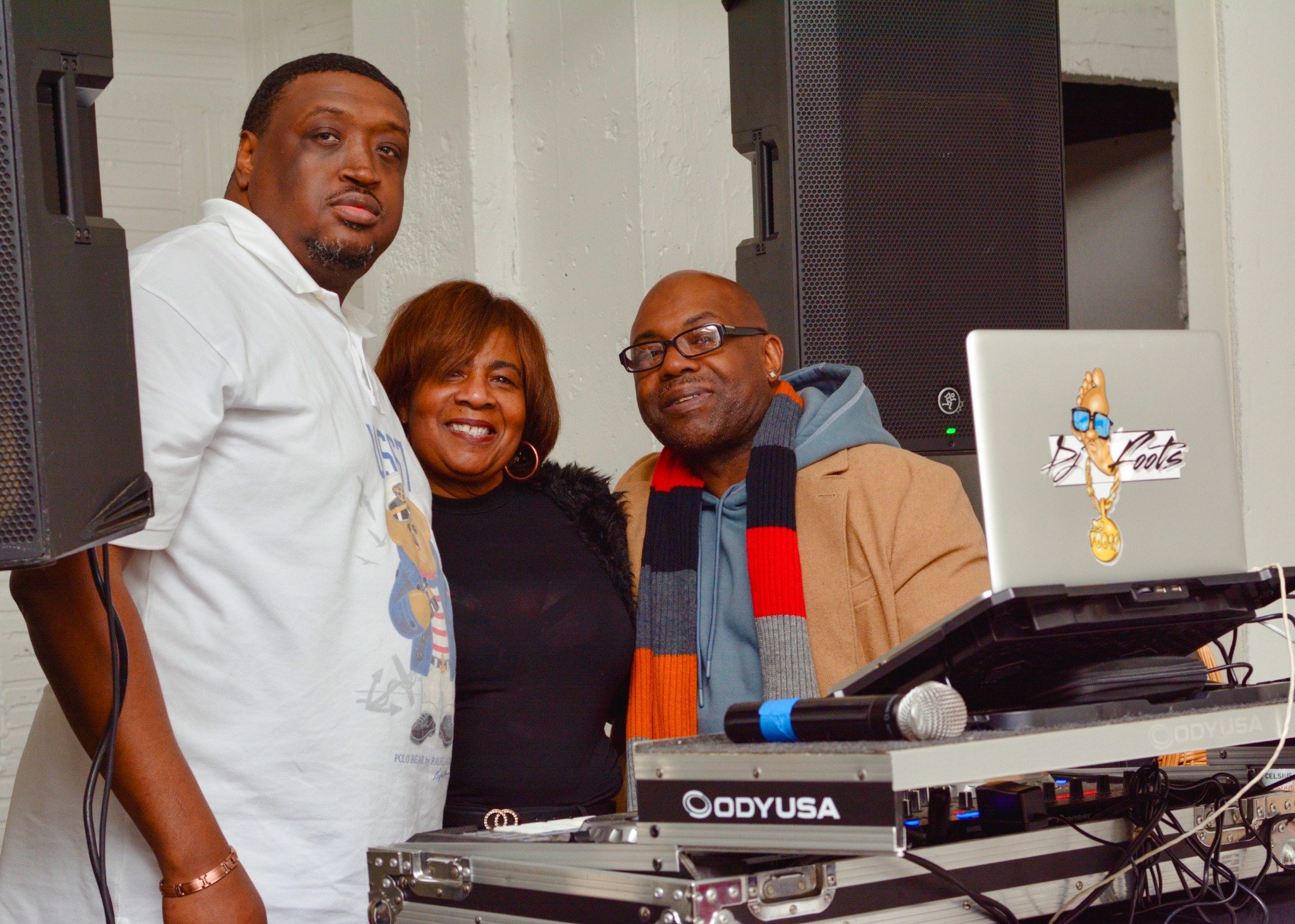 Guests beside DJ equipment at the De Barker IDWD event.