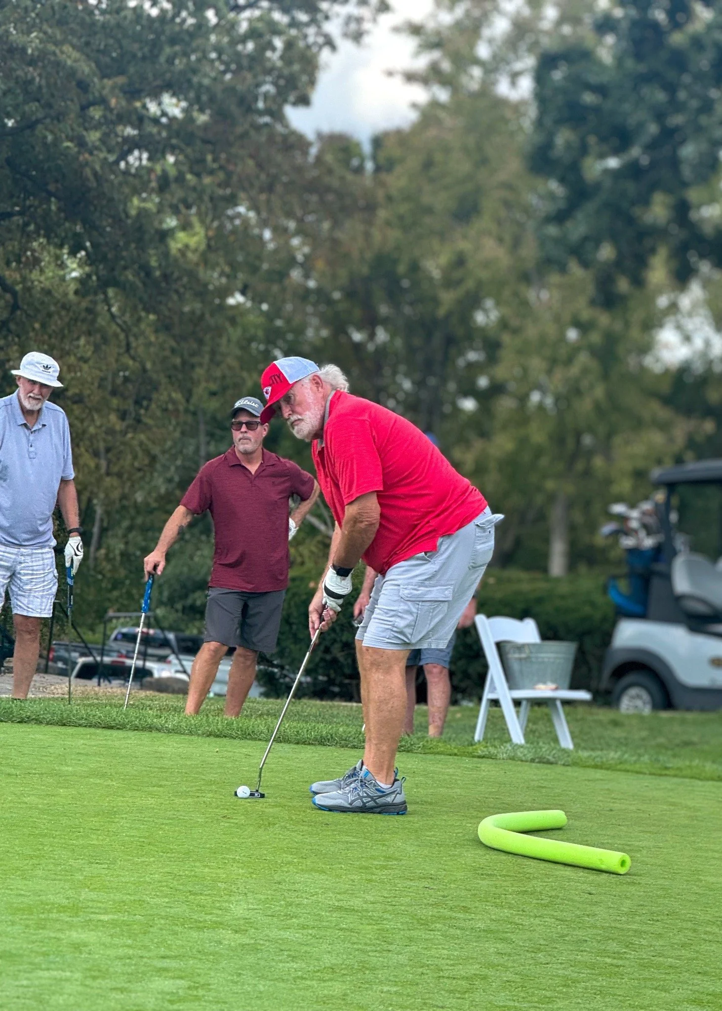 A participant putting during the ArtsTech golf tournament.