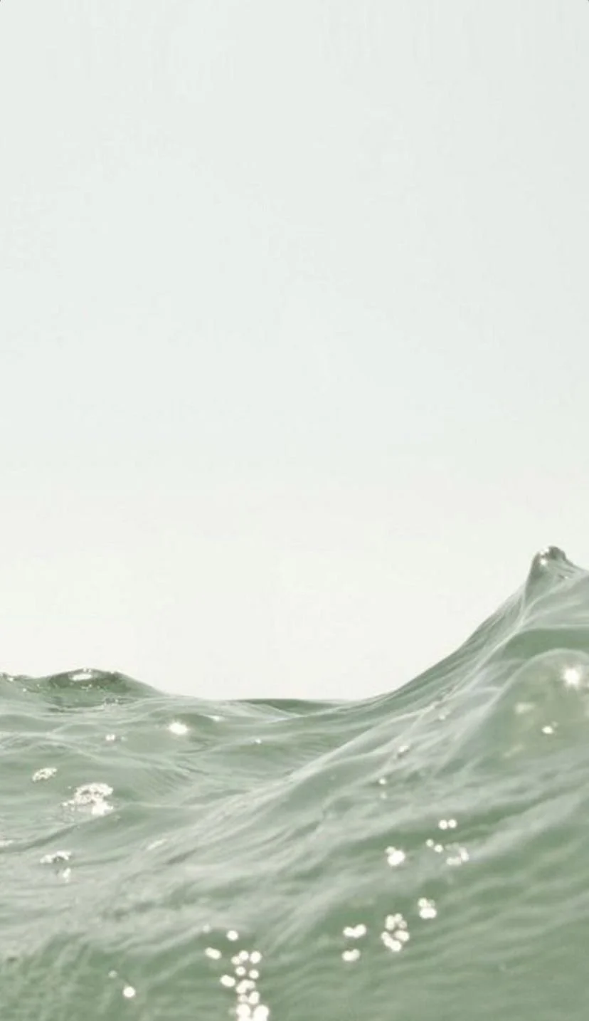 Close-up view of ocean waves with a clear, light sky in the background.