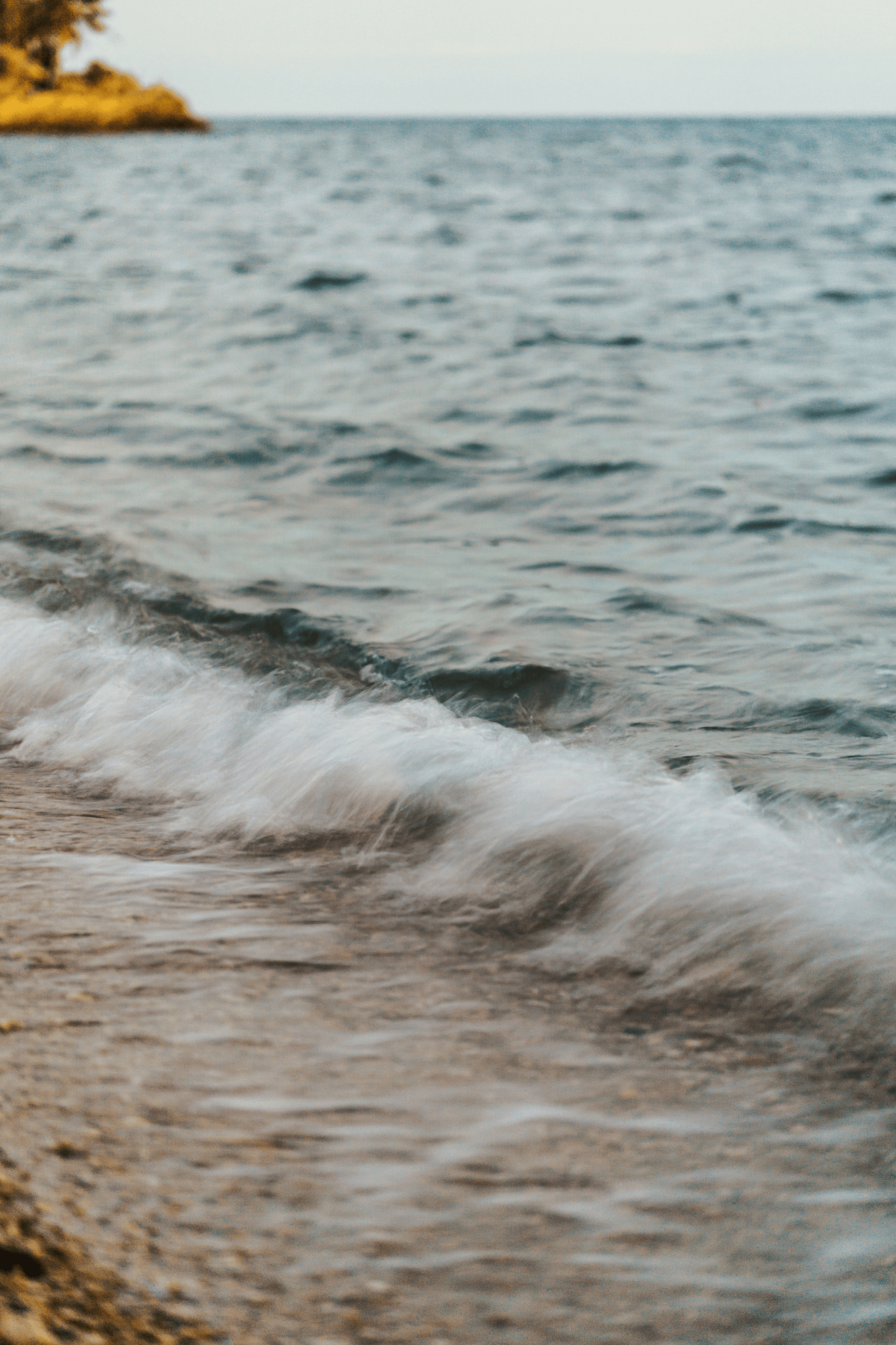 Close-up of the shoreline with gentle waves washing onto the beach on Sydney's northern beaches where celebrant Kate Cohen conducts ashes scatterings or paddle outs