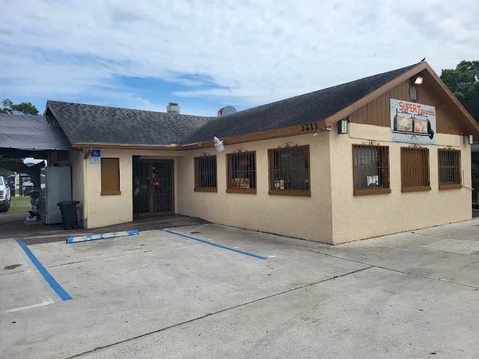 Exterior of a small restaurant with parking spaces in front, some spots marked for handicapped parking, and a sign that reads 'SUPER' along with other text.