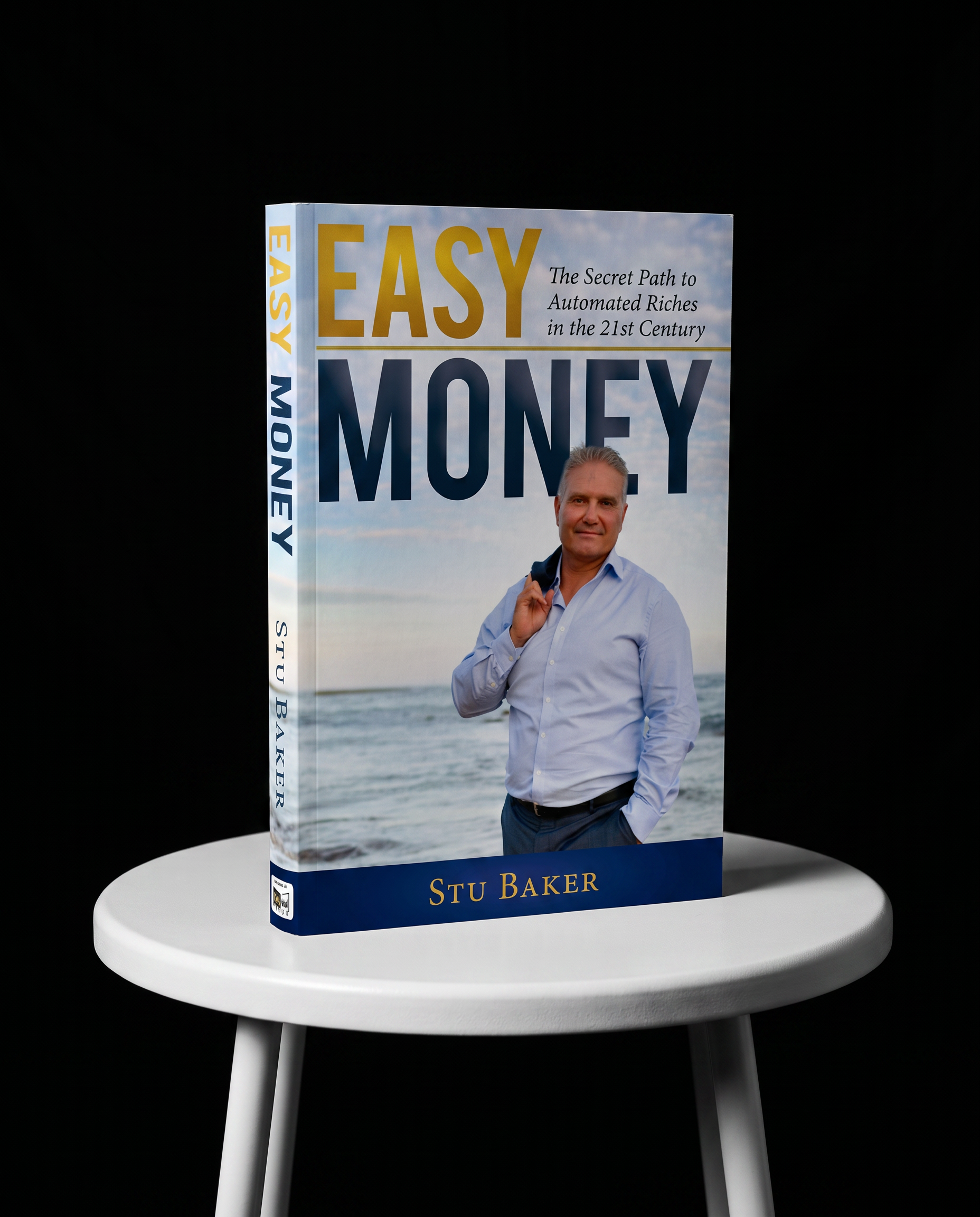 Book titled 'Easy Money' by Stu Baker on a white table with three white legs, against a black background. The cover features a man in a white shirt standing outdoors near the beach with sky and ocean background.