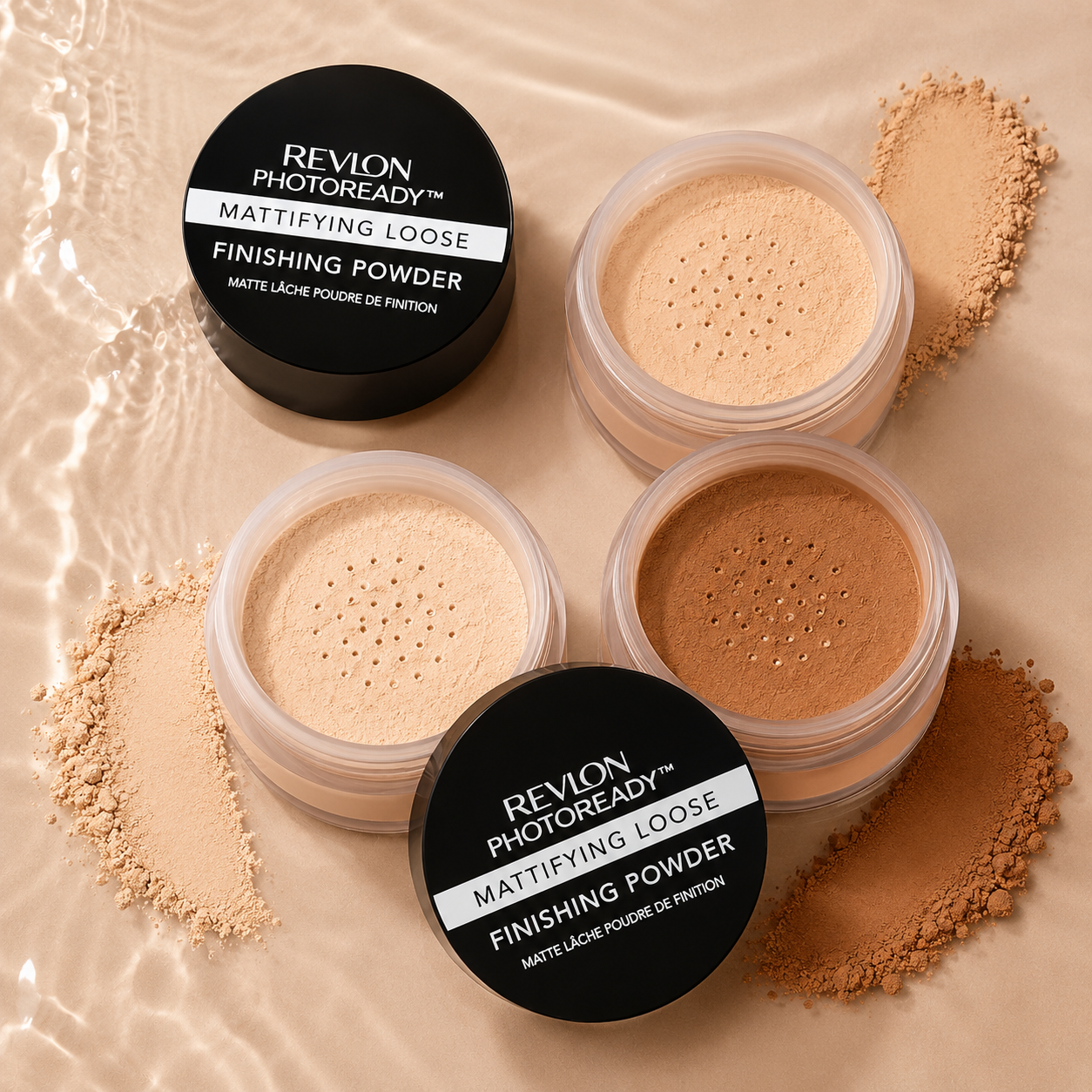 Three open containers of Revlon Photoready Mattifying Loose Finishing Powder in varying shades, with loose powder spilled around them on a beige surface with water reflection.