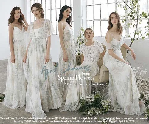 Five women wearing white floral dresses in a bright room with large windows and plants, promoting floral shower spring flowers dresses on sale.