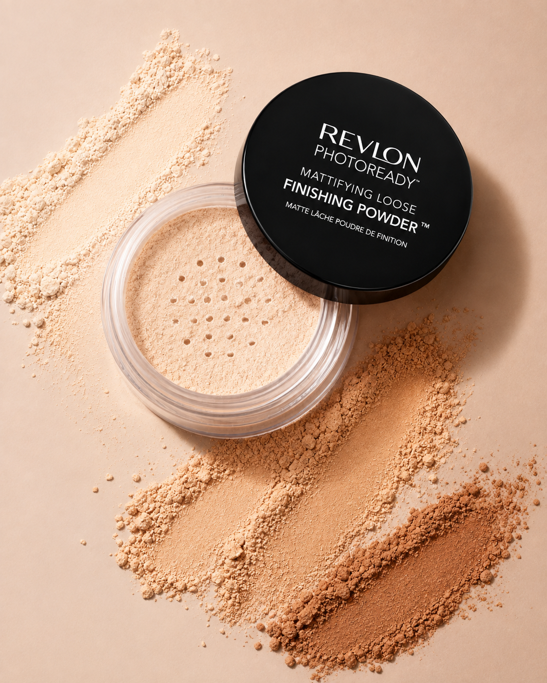 Open container of Revlon PhotoReady Mattifying Loose Finishing Powder with loose powder spilled on beige surface, arranged in lines.