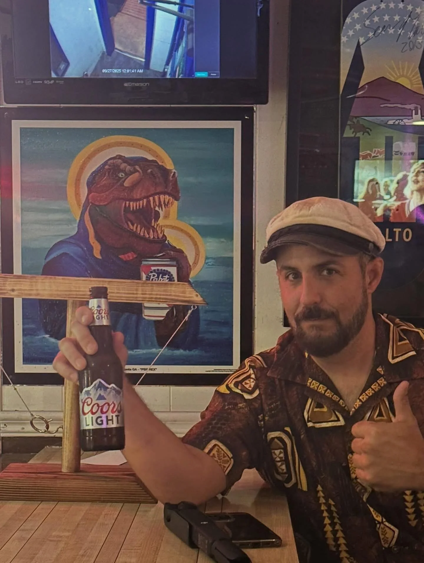 Visitor showing framed artwork inside 403 Club, surrounded by colorful bar décor and Kansas City neighborhood charm.