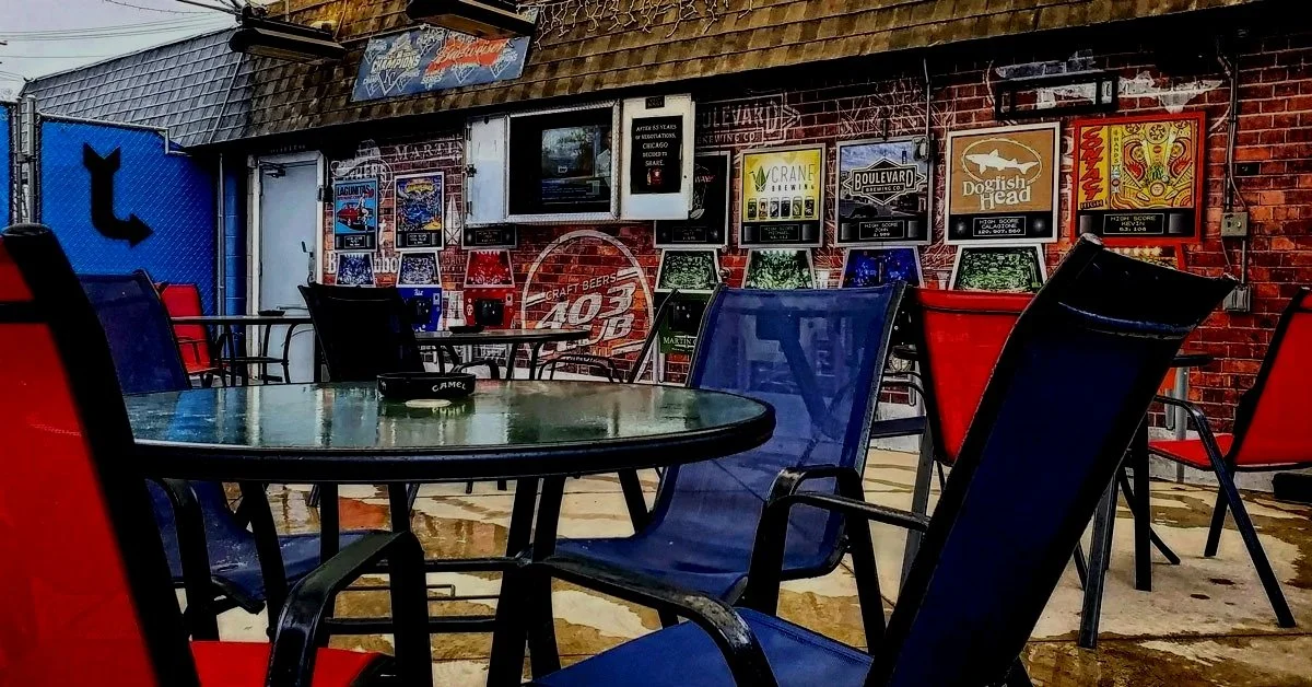 403 Club’s outdoor patio with red and blue seating in Strawberry Hill, Kansas City, offering year‑round covered hangout space.