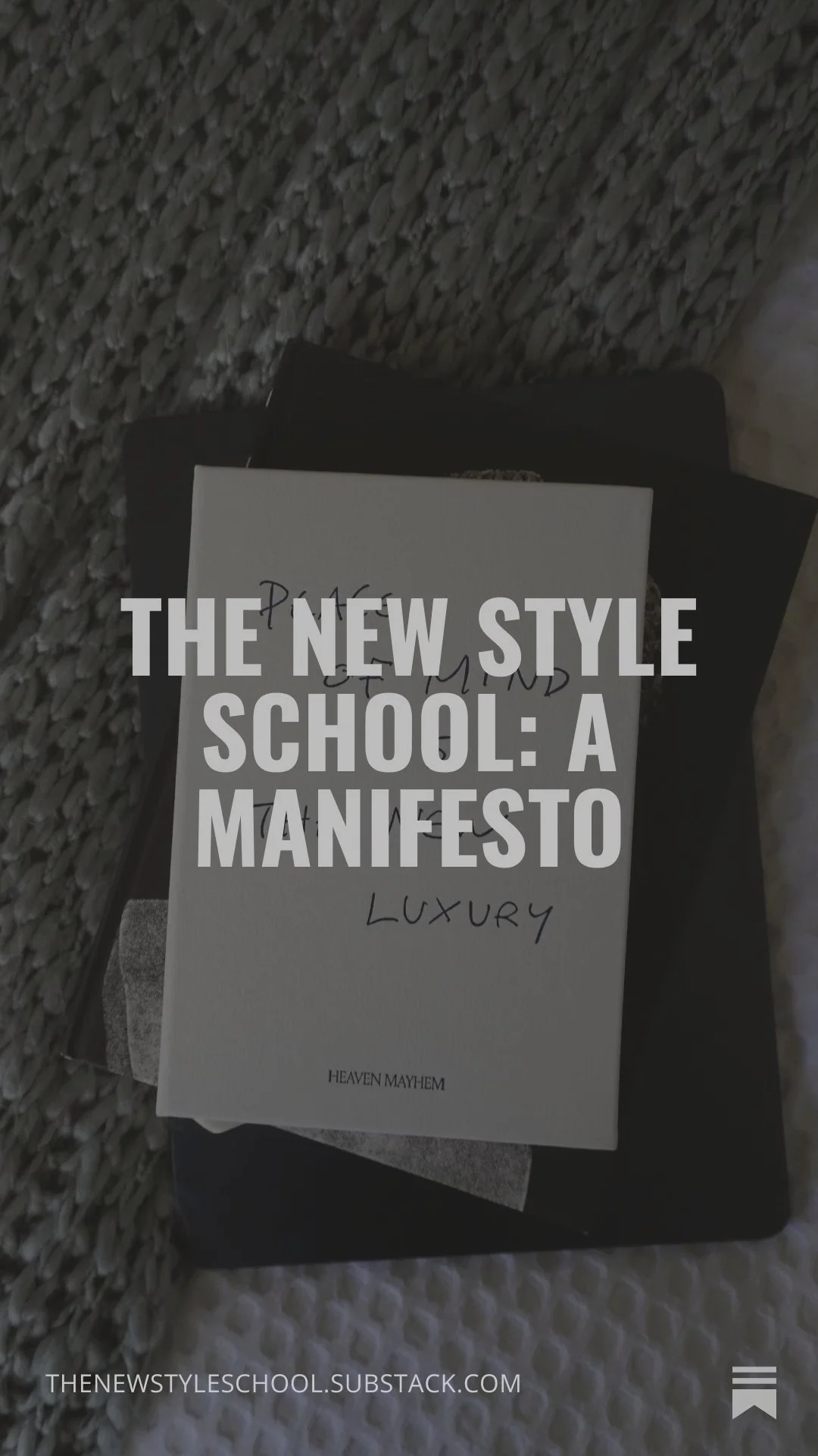 Close-up of a book titled "The New Style School: A Manifesto" by Heaven Mayhem, lying on a textured gray carpet, with another dark book partially underneath.
