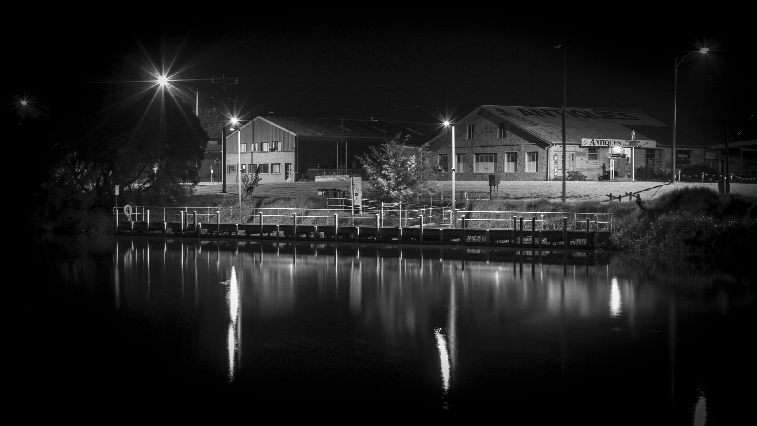 The old butter factory reflected in the still waters of the Mitchell River at night.