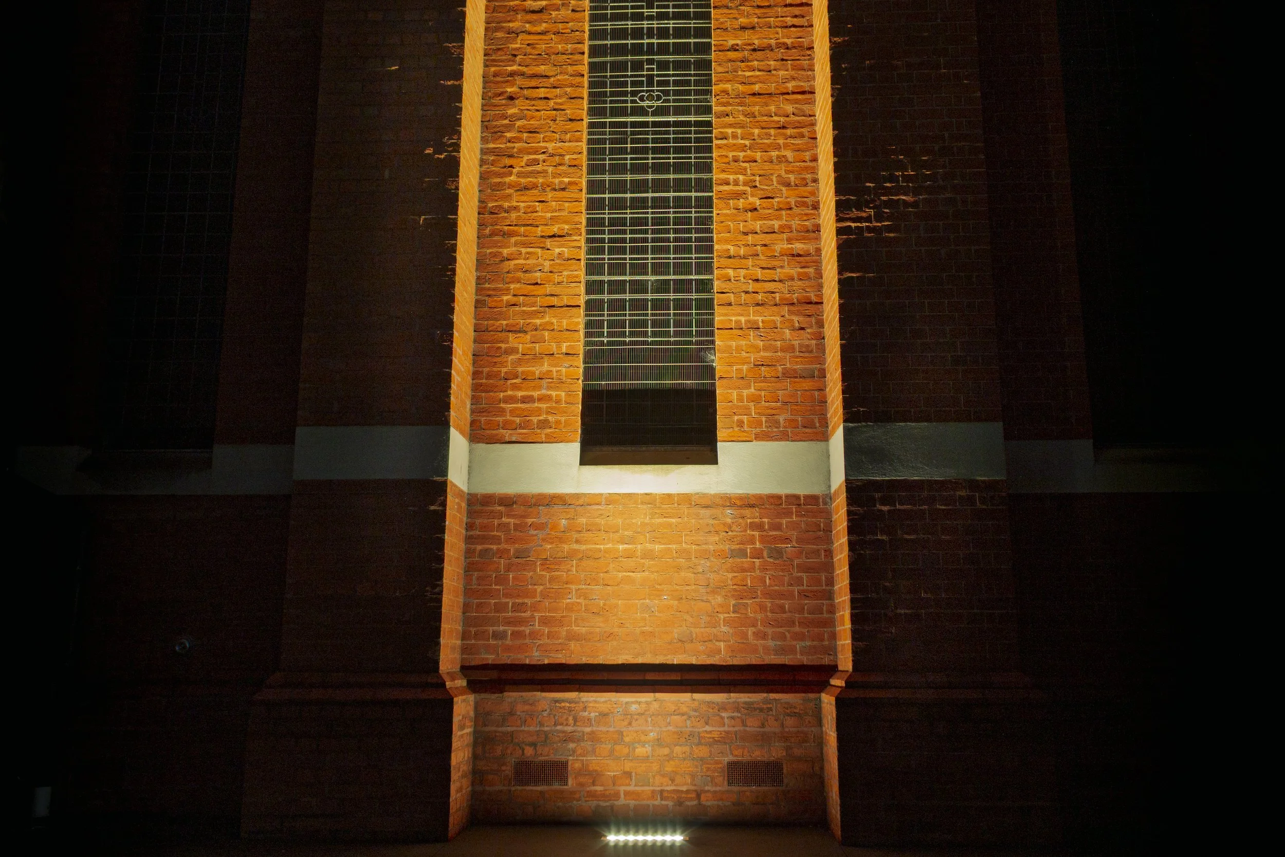 Uplit brickwork around a tall window at St Mary's Church, Bairnsdale