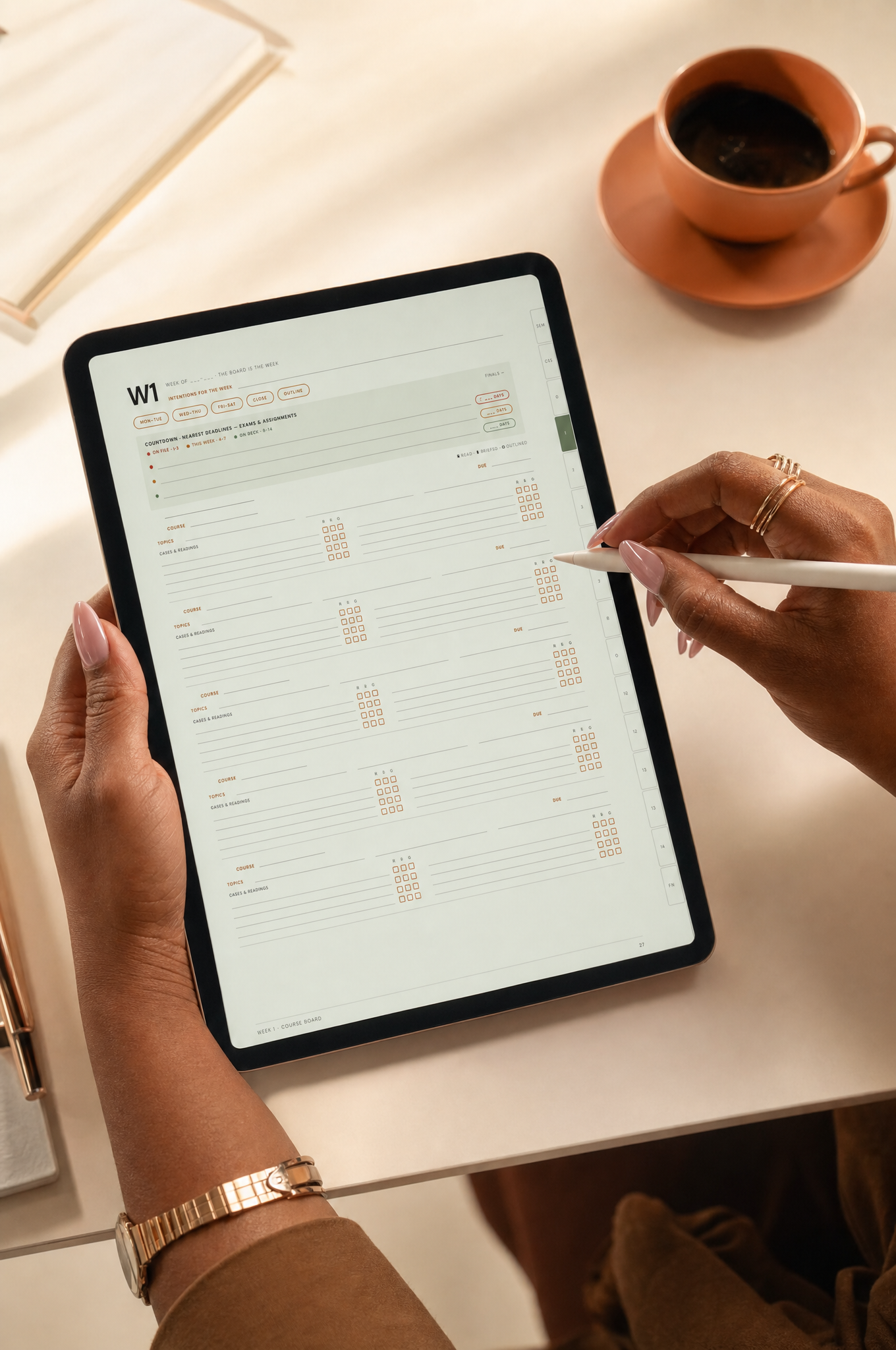 Person holding a tablet with a planner app open, writing with a stylus, on a white table next to a cup of coffee on a saucer.