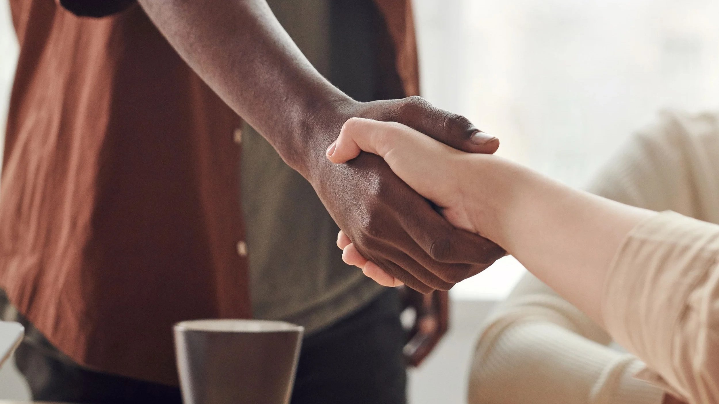 Two people are holding hands in a gesture of support and solidarity.