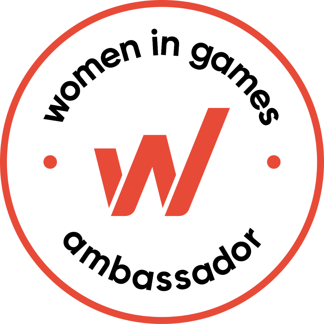 Circular logo with black text: 'women in games ambassador' around a stylized red W in the center, all outlined with a red border.