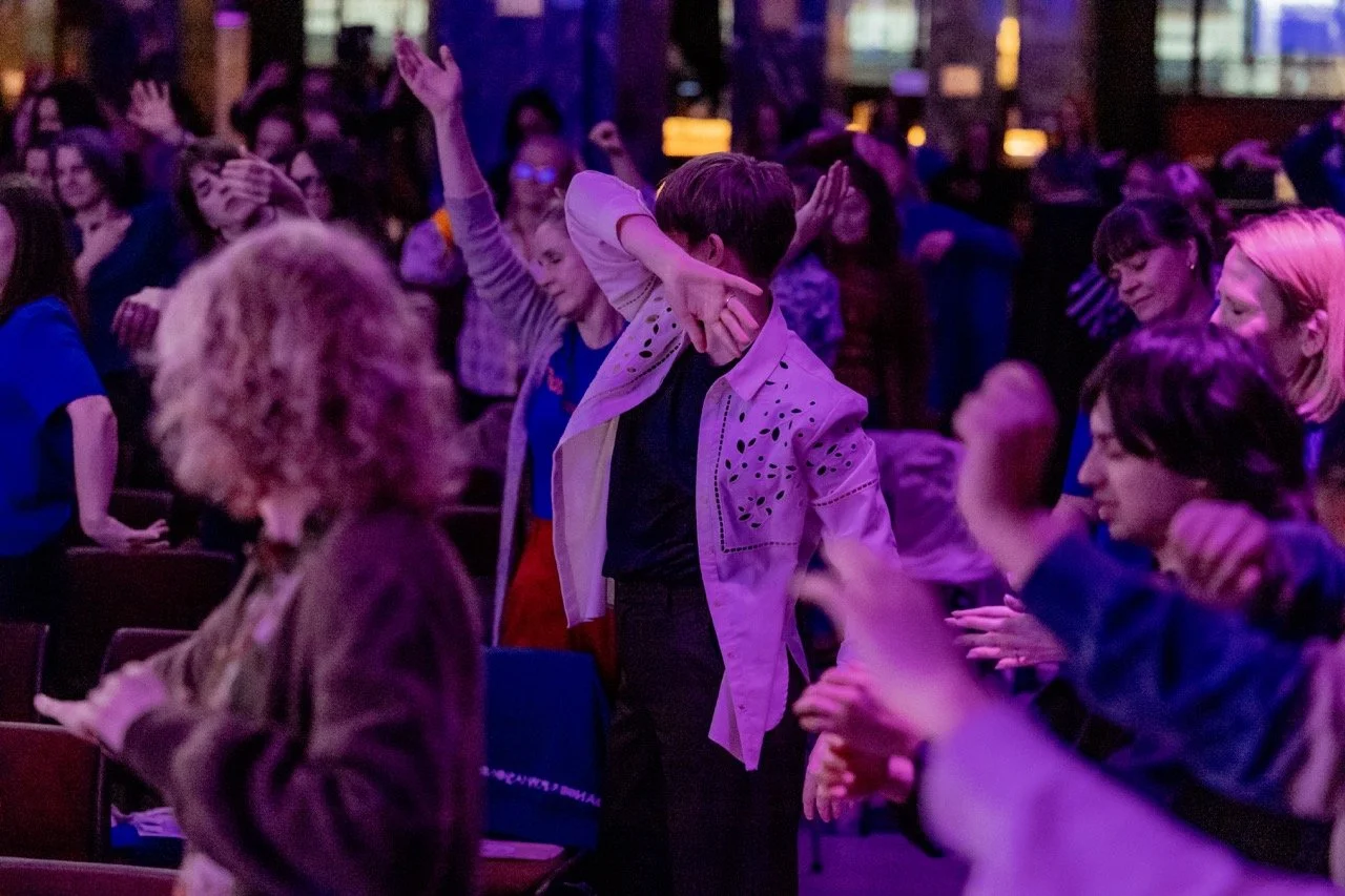 Mennesker danser og har det gøy på en konsert eller festival med fargerik belysning.