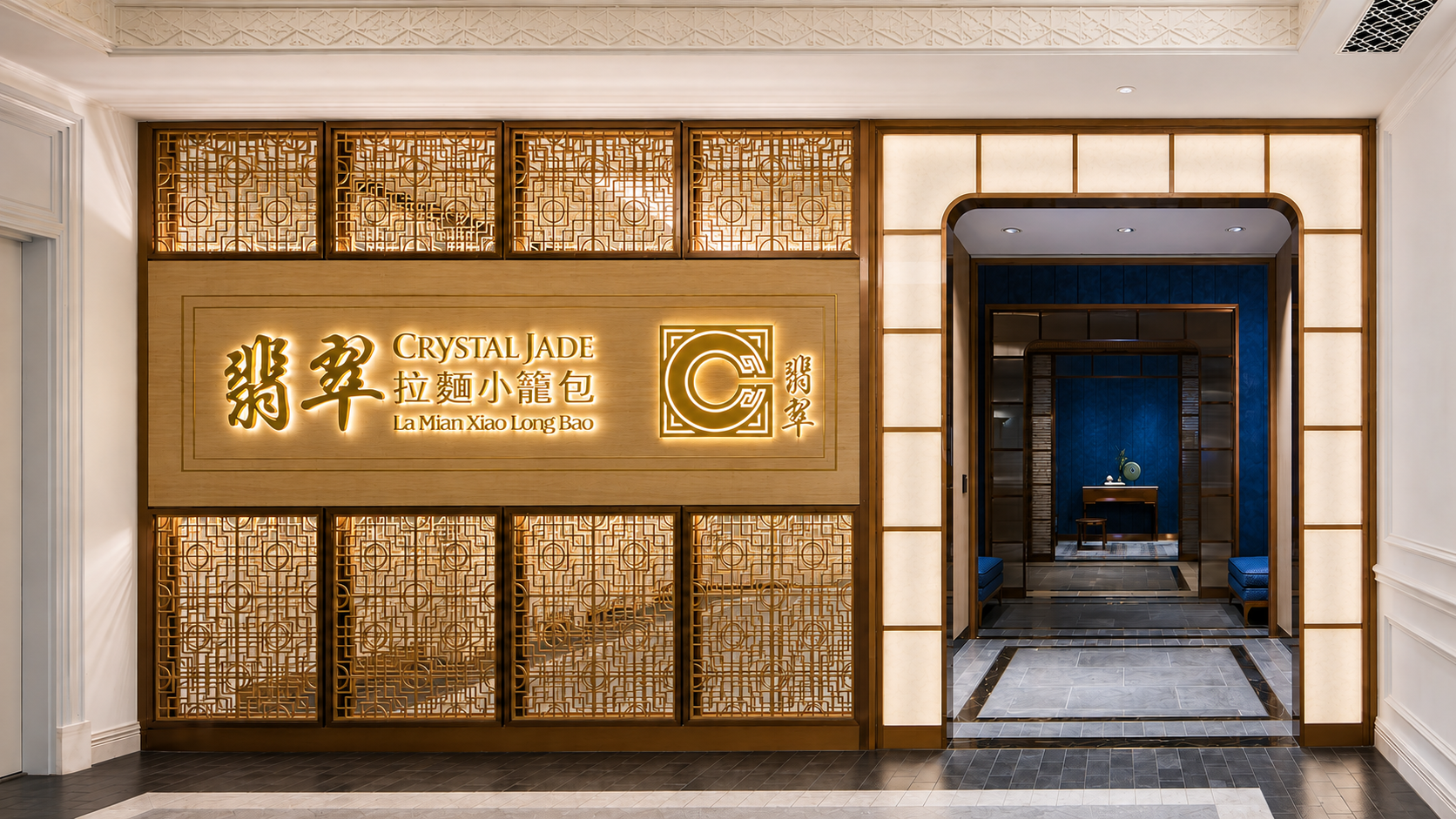 Entrance to a restaurant called 'Crystal Jade La Mian Xiao Long Bao' with traditional Chinese design elements and illuminated sign