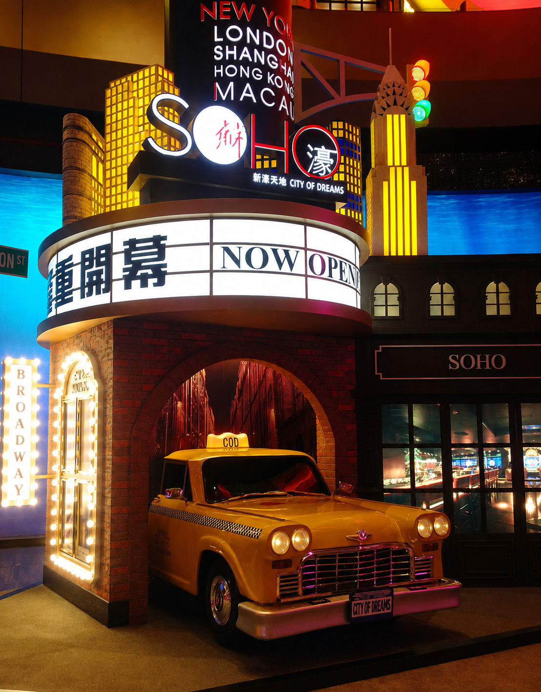 Brightly lit city-themed display with a yellow taxi cab, neon signs, and a traffic light, representing the New York City skyline.