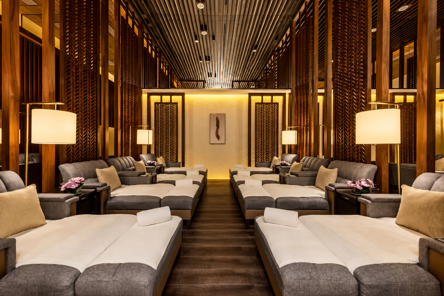 Elegant hotel lounge with gray and cream seating, wooden dividers, and warm lighting.