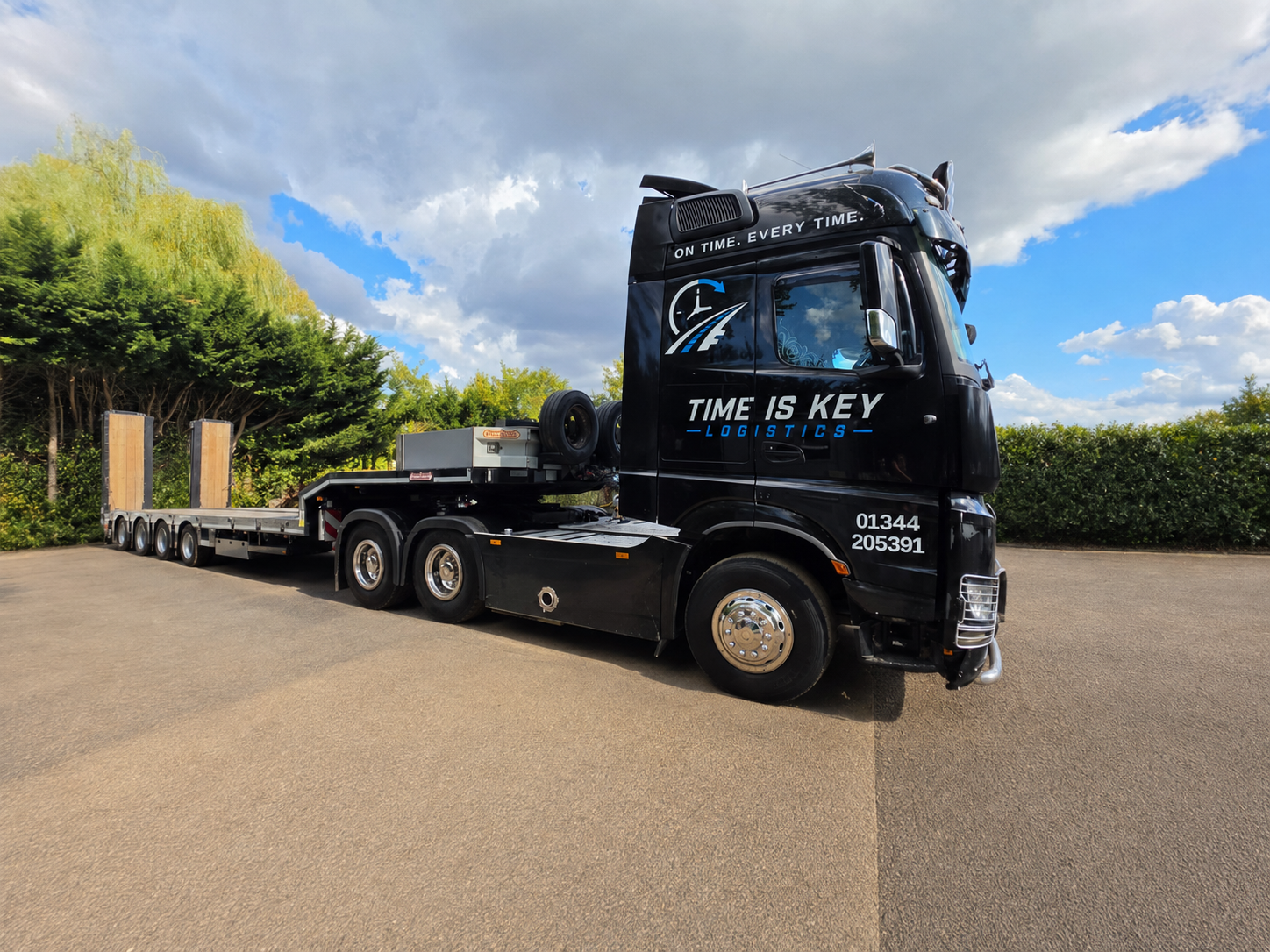 Time Is Key Logistics black articulated lorry with specialist low-loader trailer