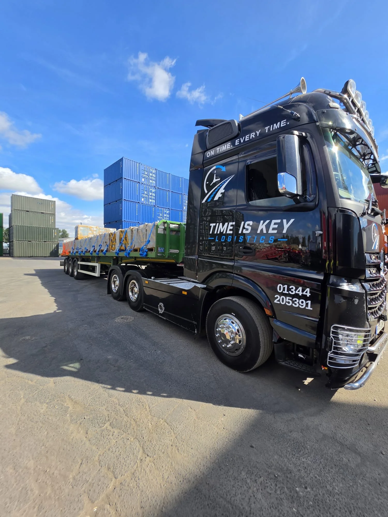Time Is Key Logistics lorry parked beside shipping containers during a commercial haulage job