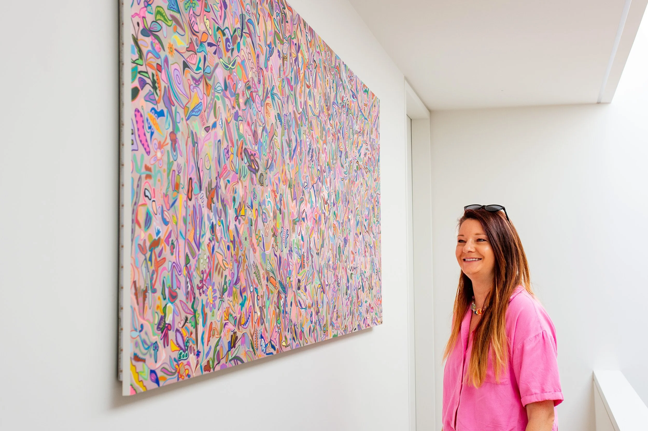Smiling Artist standing in front of a large canvas