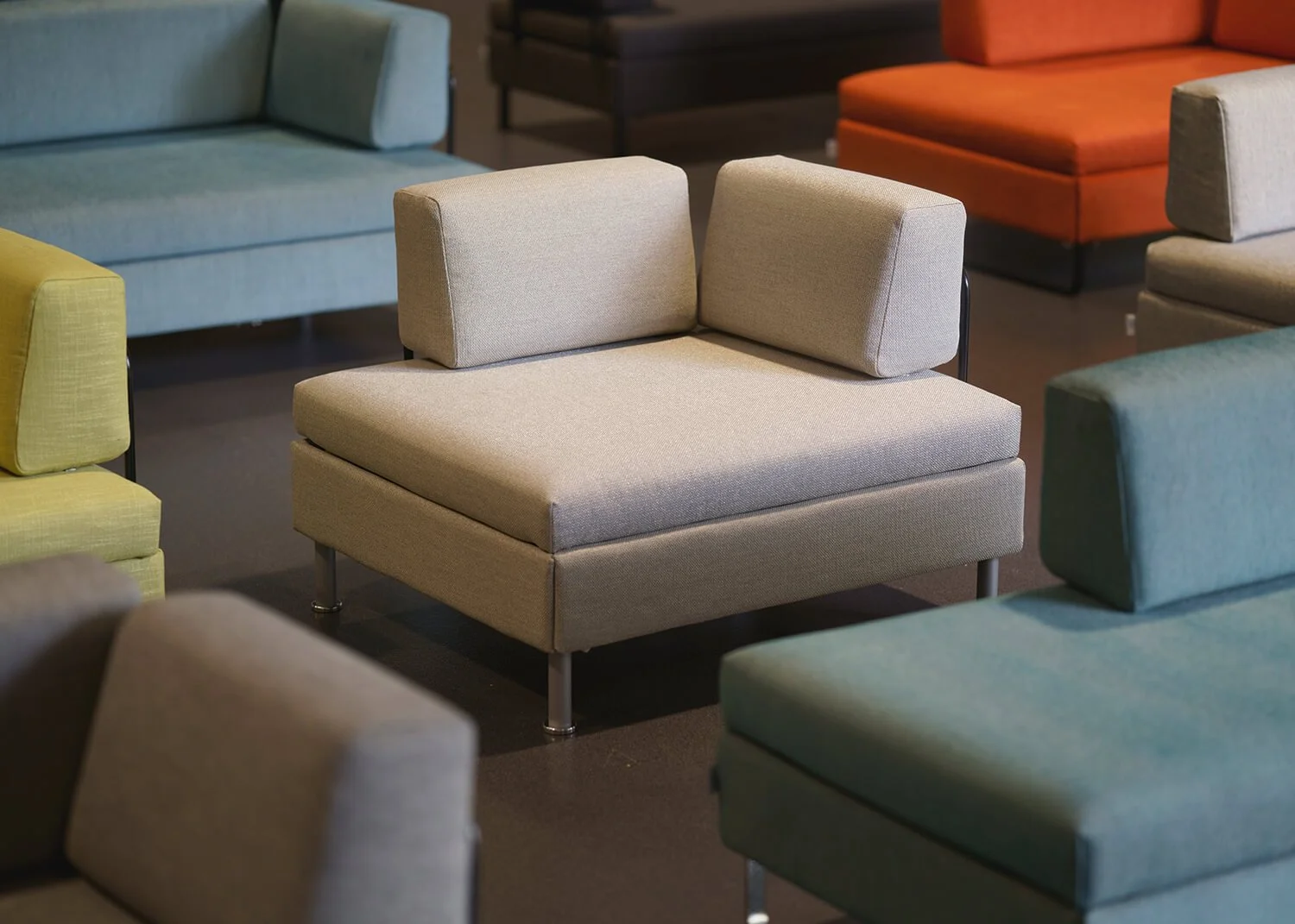 Industriefotografie von modernen Bettsesseln der Marke BED for LIVING aus Zürich. Sie stehen in bunten Farben in der Produktionshalle der Firma Swiss Plus.