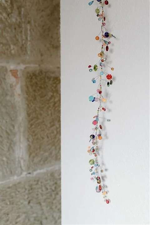 Glasperlenkette vor weisser Wand