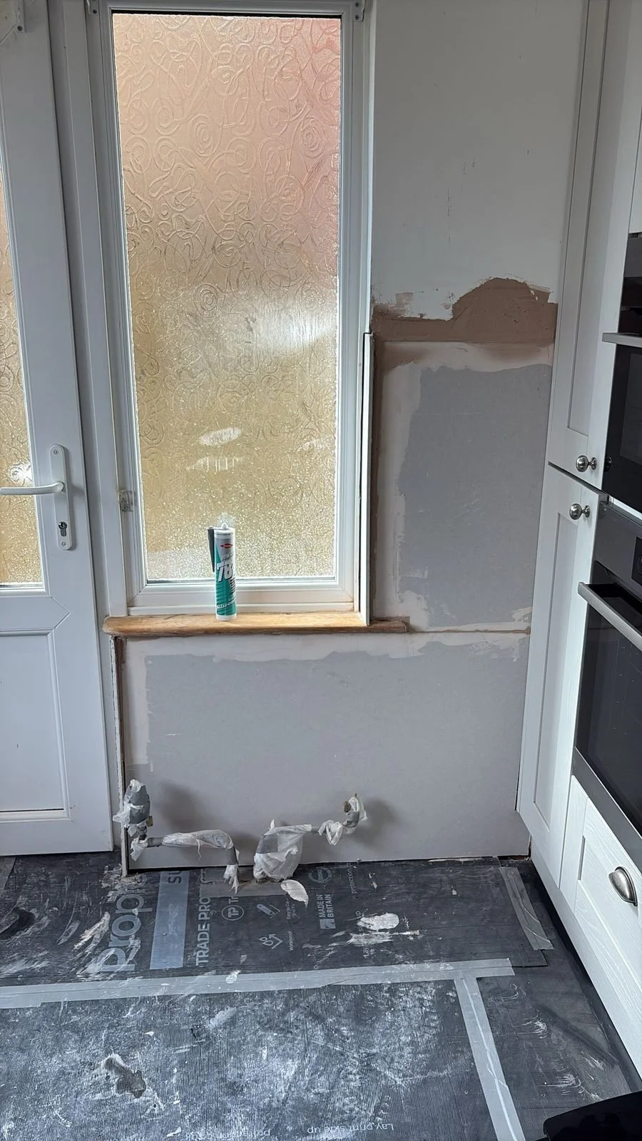 During: kitchen wall boarded after damp treatment — Hastings