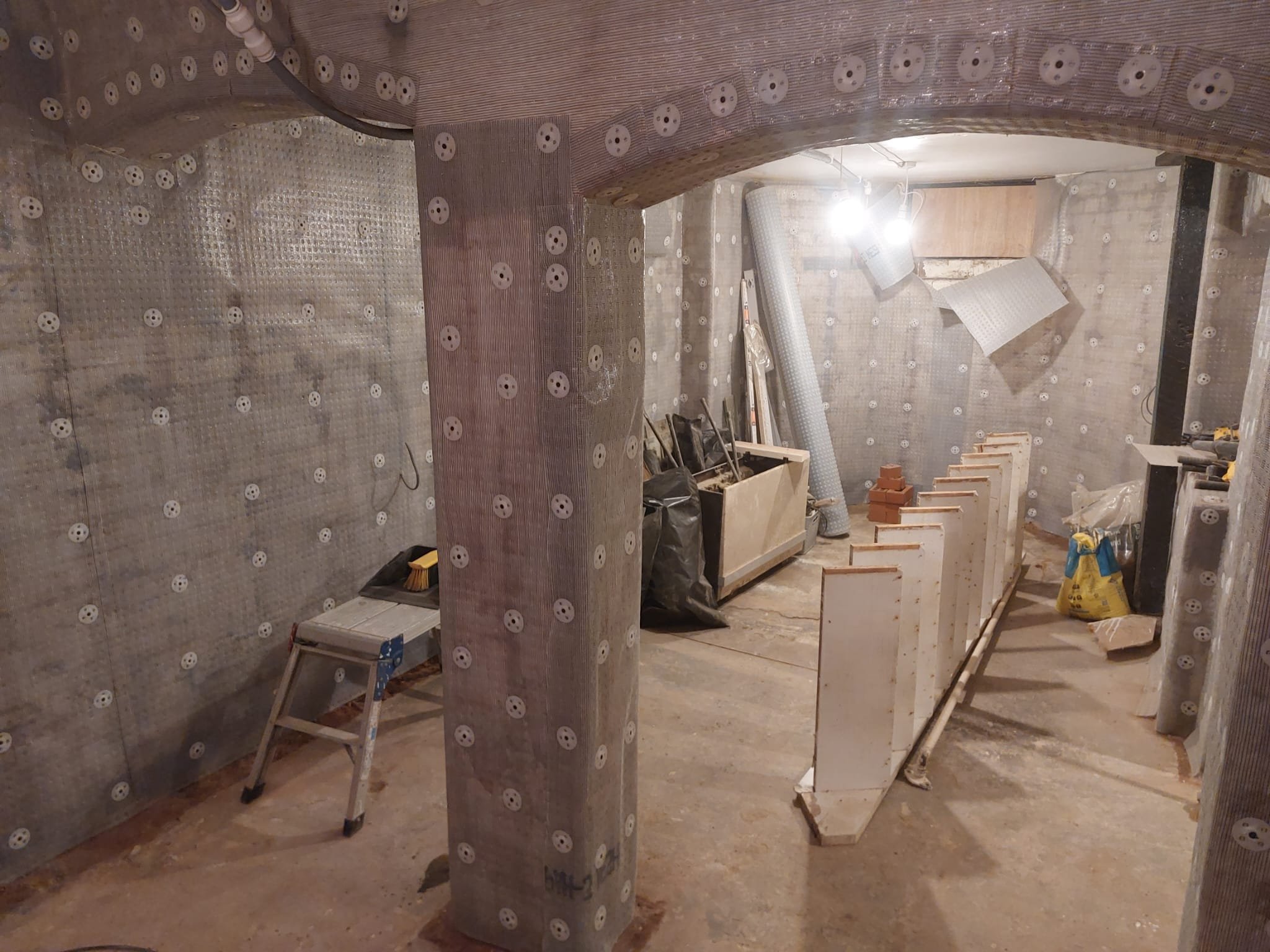 Waterproofing membrane carefully detailed around basement arches and columns.