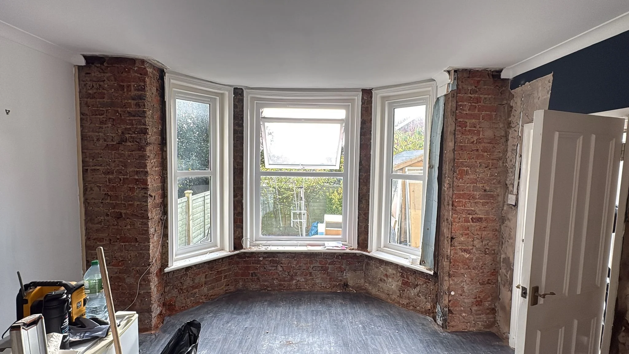 Bay-window damp remedial works in progress with affected finishes removed.