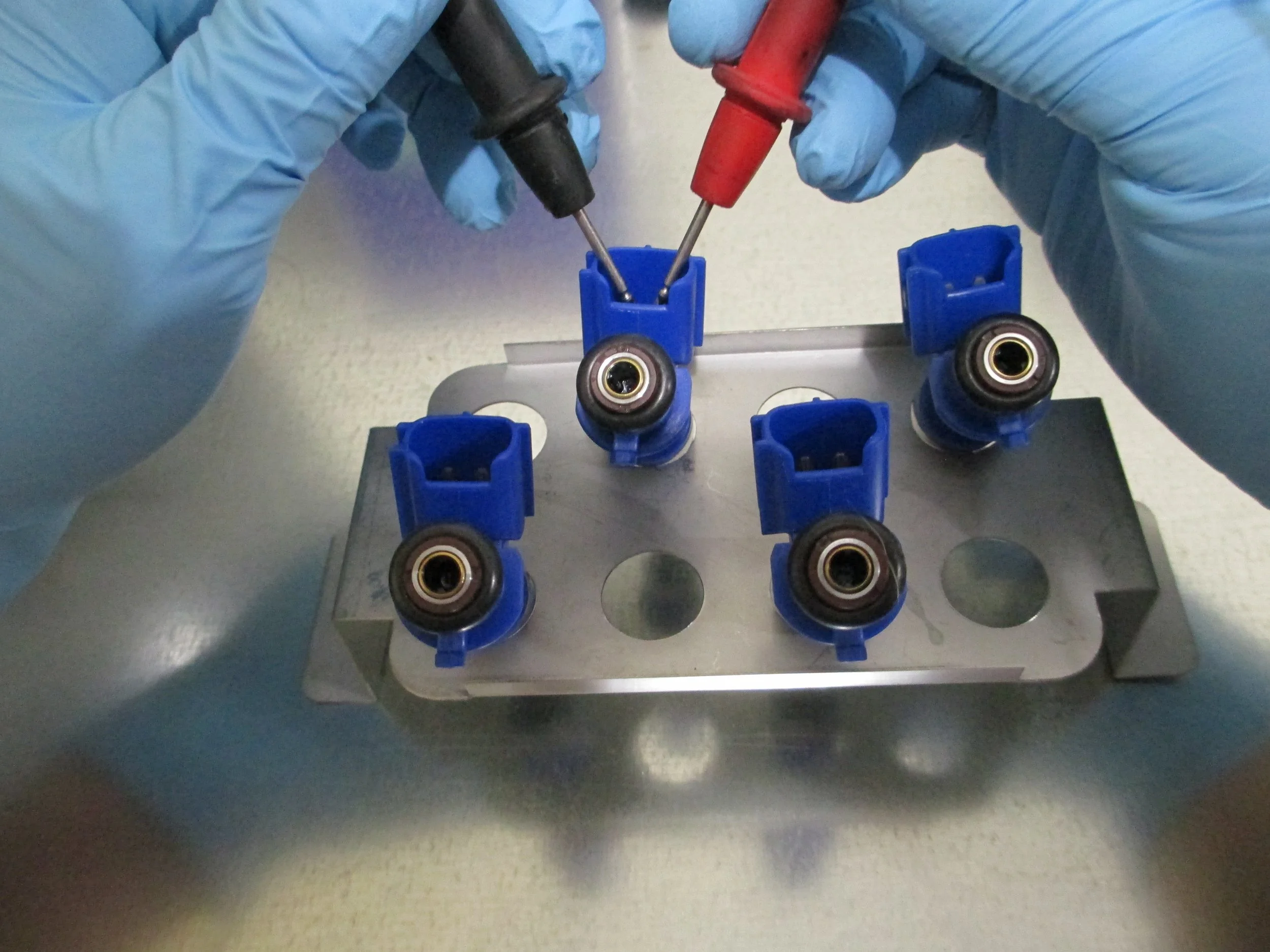 Close-up of injectors being tested through basic continuity test.