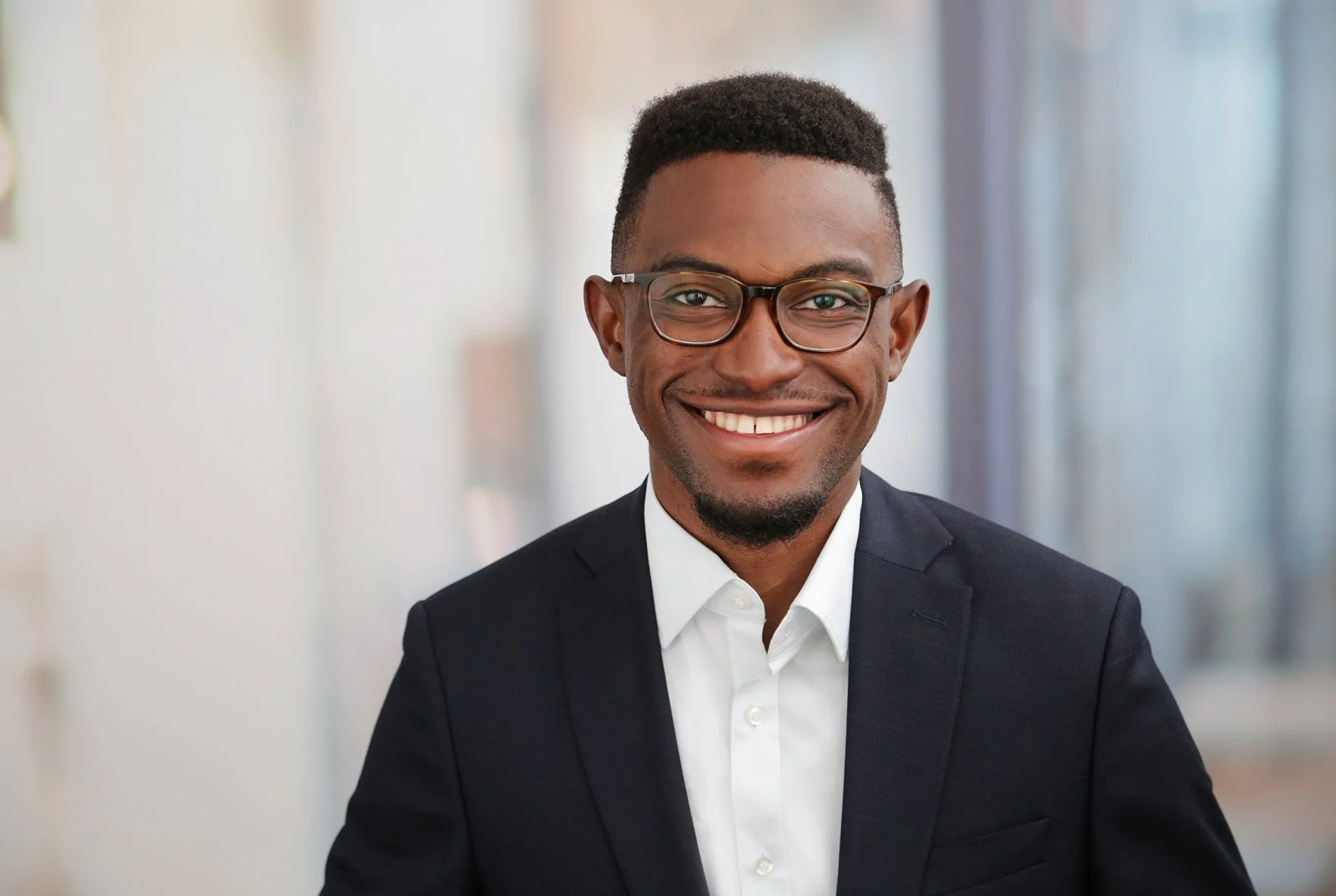 Business Portrait - Lächelnder Mann in Anzug und Brille im Büro