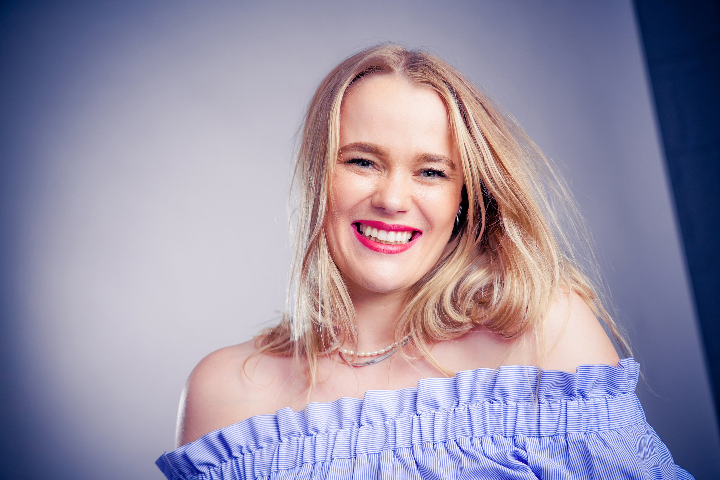 Studioportrait mit einer jungen Frau mit pinken Lippen und blonden Haaren