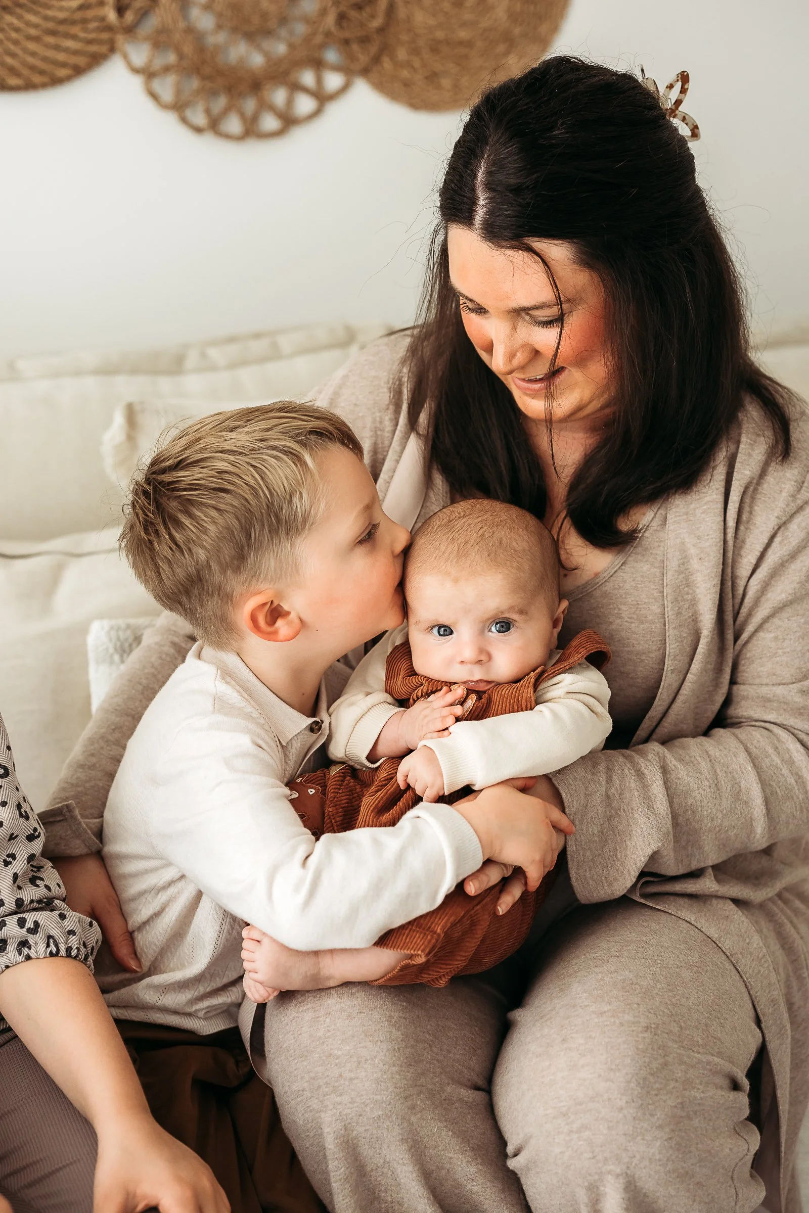 A loving family moment as an older sibling gently connects with their baby brother or sister, capturing the bond and affection between them.