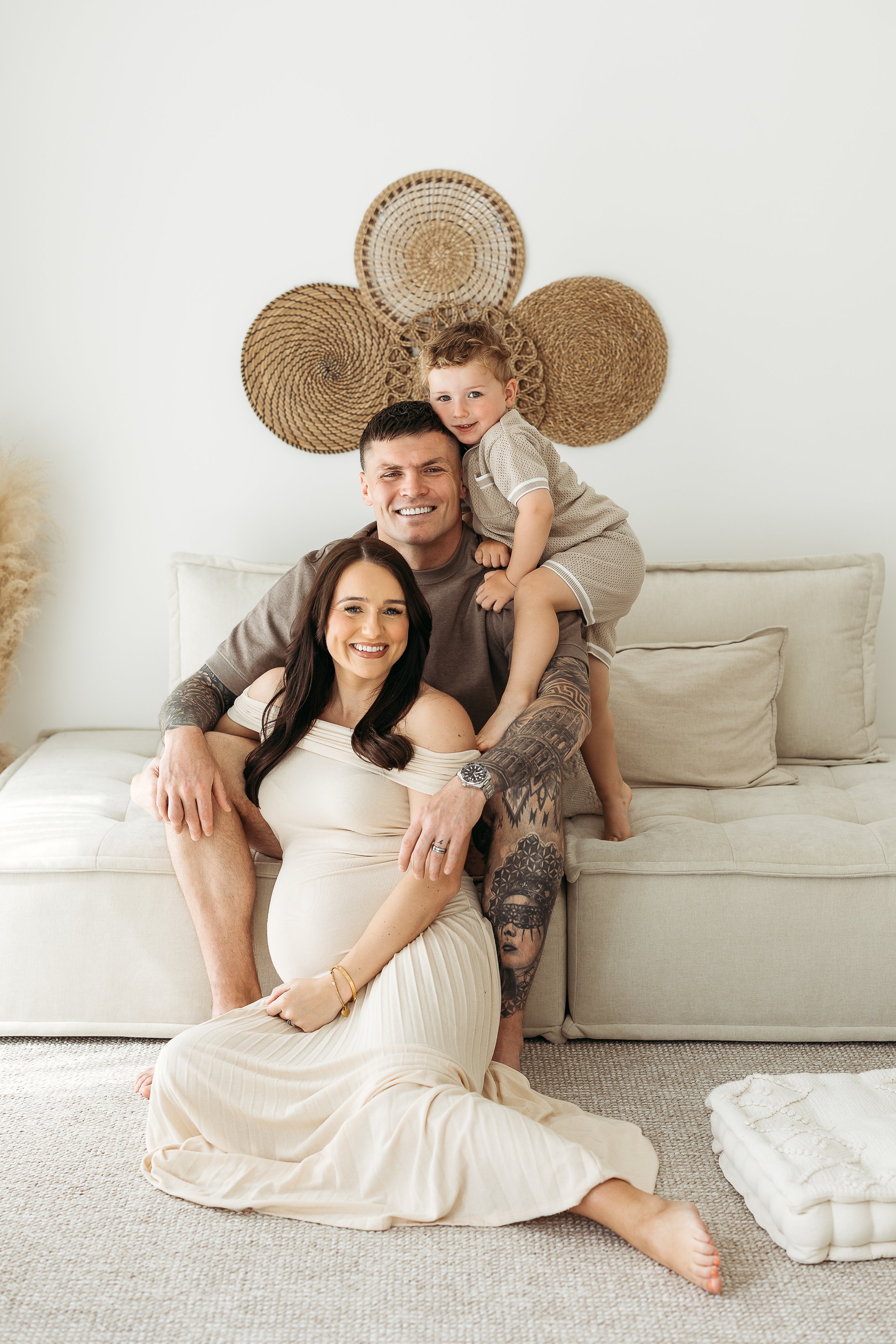 A family of four sharing a loving moment together during a maternity photography session before welcoming their new baby.
