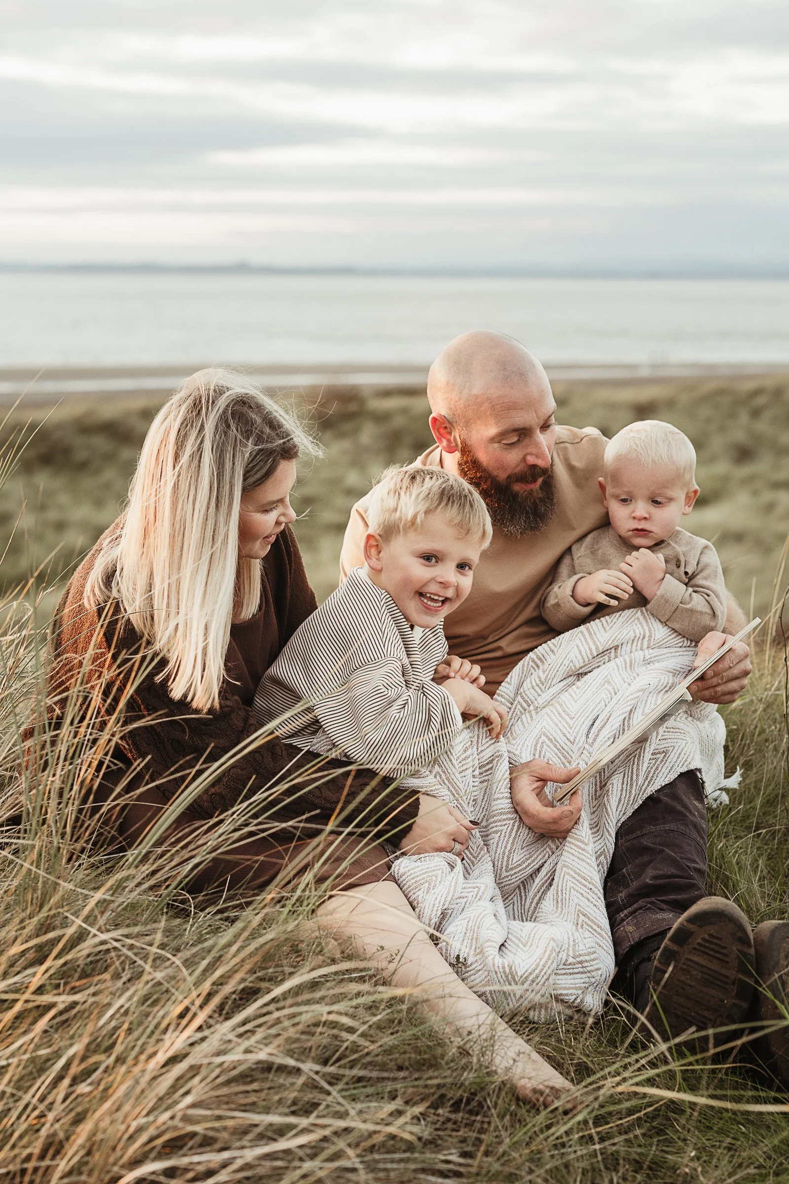 A family of five enjoying a quiet moment together outdoors, capturing connection, togetherness and the simple joy of being a family.