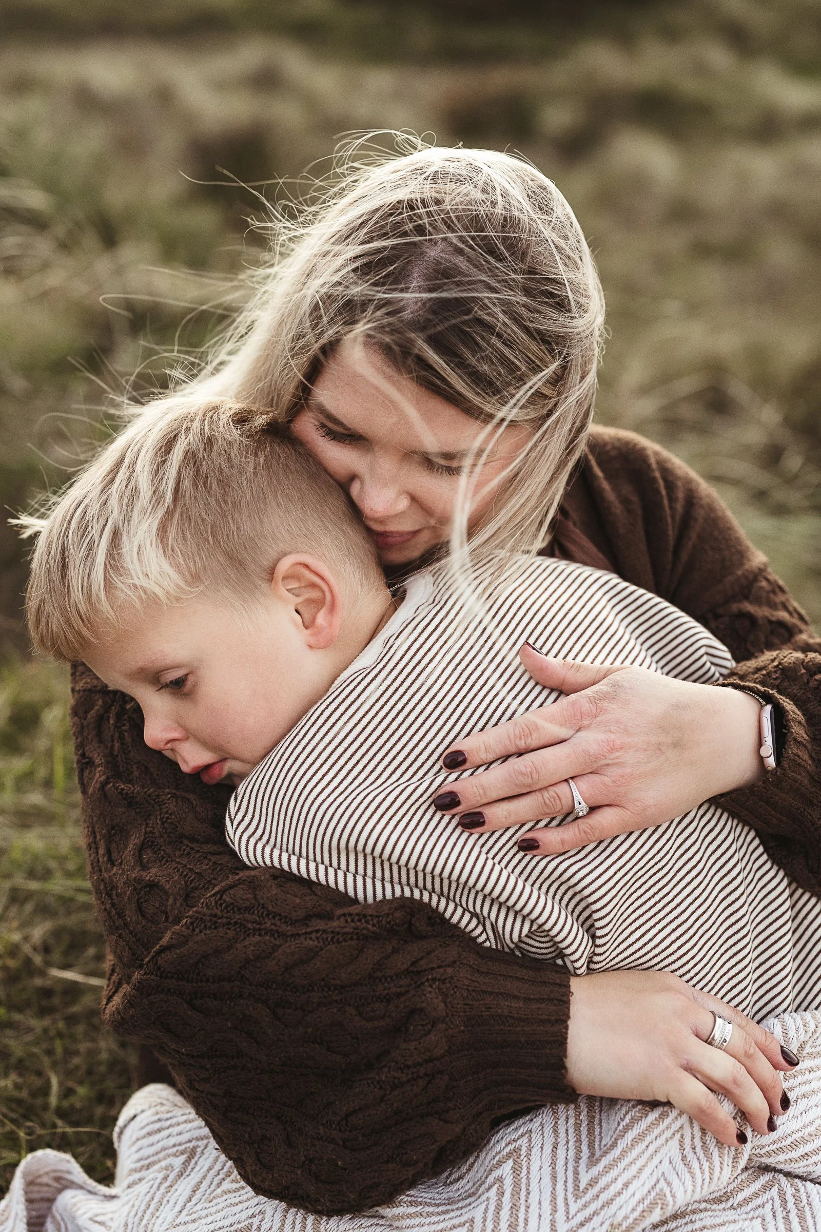 A mother and child sharing a loving cuddle outdoors, preserving the closeness and bond between them.